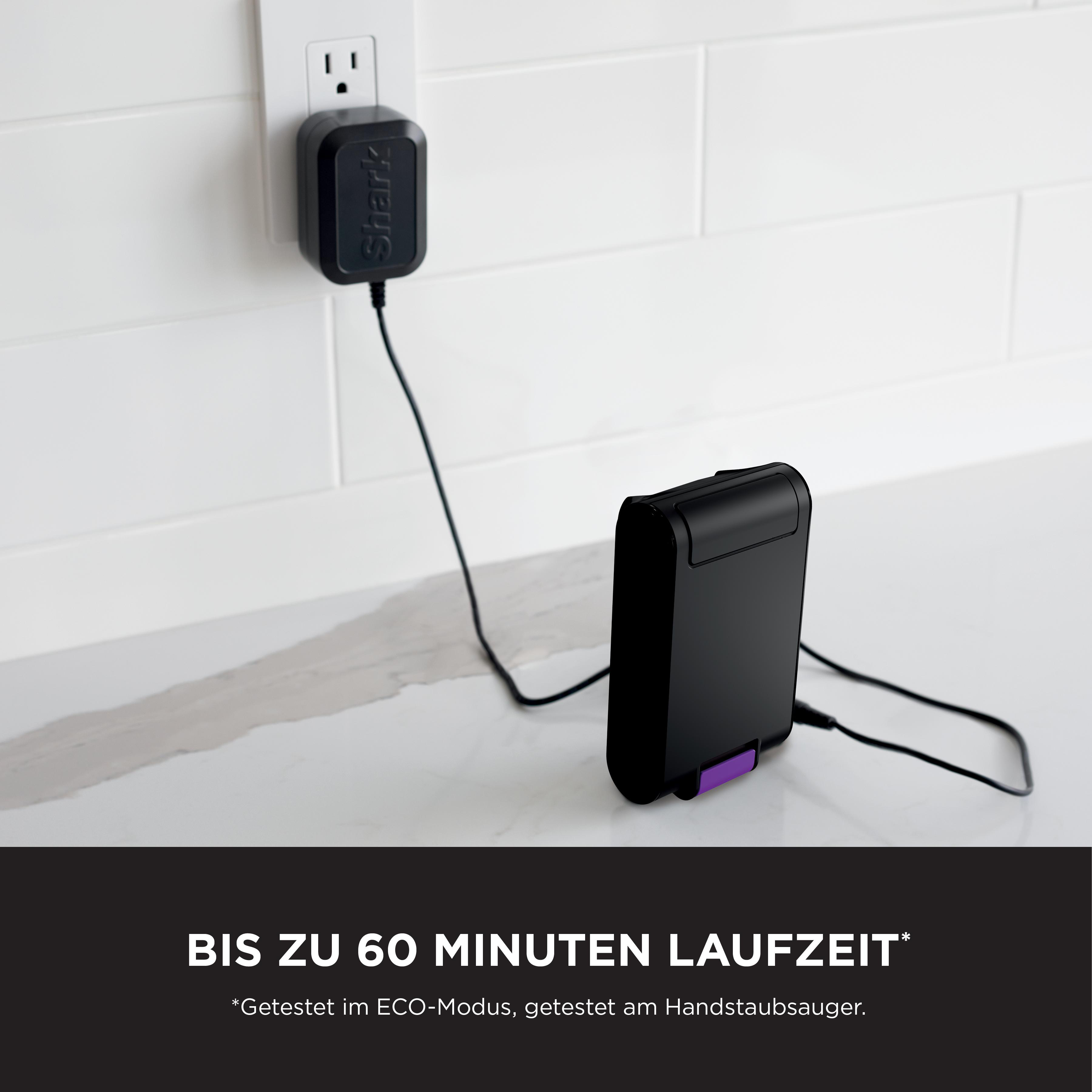 Eine silberne Schreibtischlampe oben auf einem Computermonitor, über einem Schreibtisch mit Papieren.