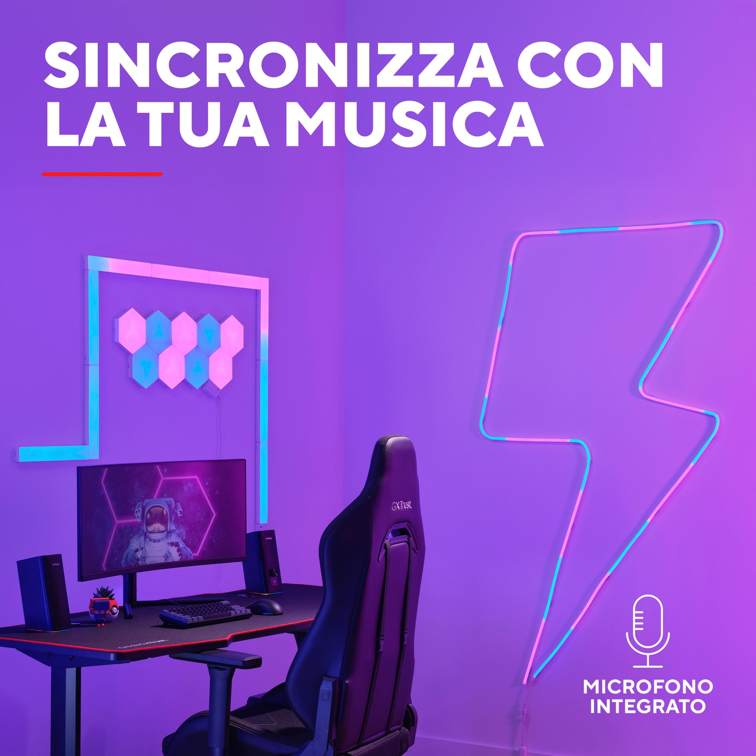 L'immagine mostra un setup di gioco con un monitor, una scrivania e una luce al neon a forma di fulmine rosa e blu.