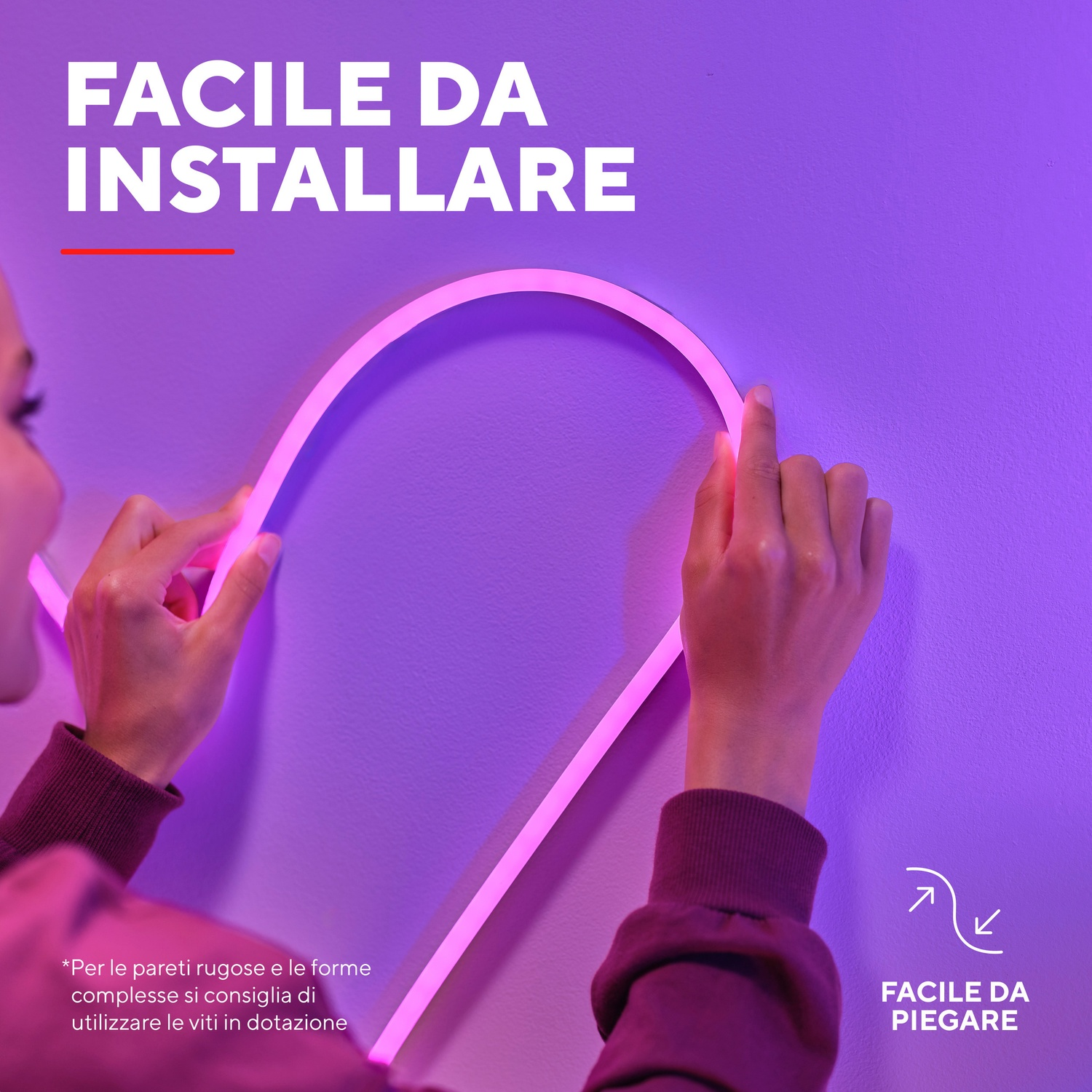 Una donna installa strisce luminose a LED rosa su un muro viola. Il testo dice 'Facile da installare'.