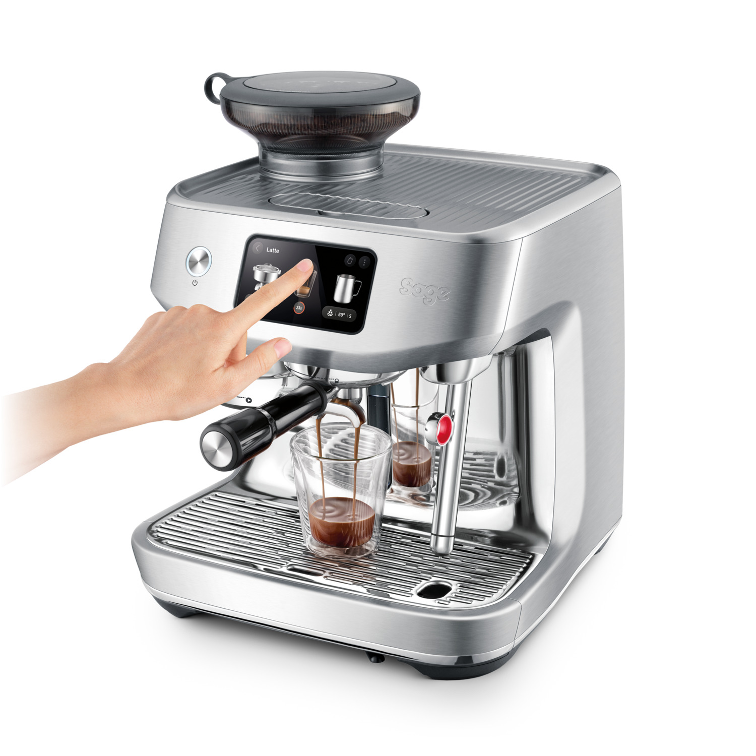 Une machine à café argentée avec une main touchant l'écran, un verre de café est visible.