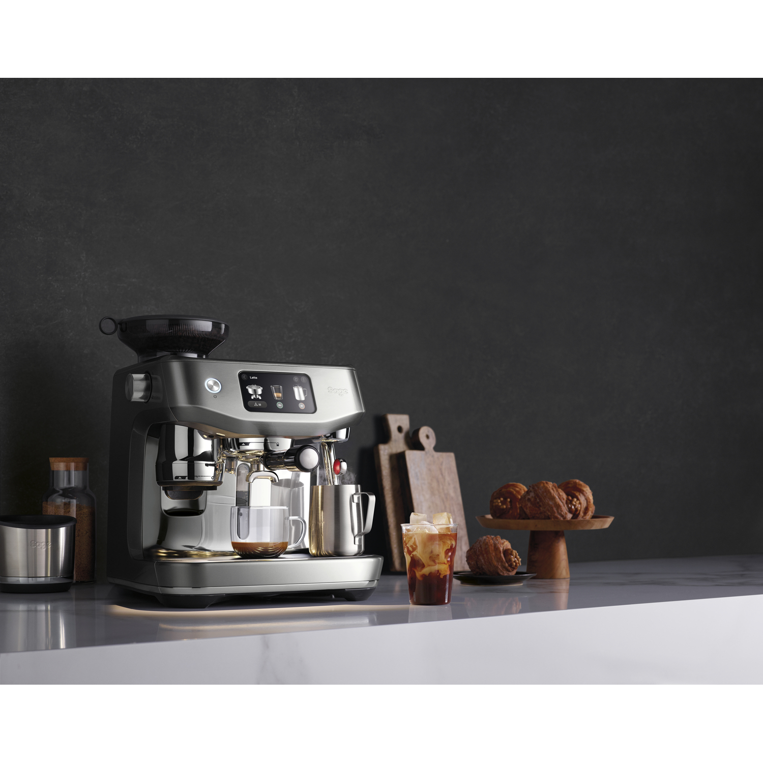 Machine à expresso avec tasse de café. Croissants sur planche de bois. Café glacé. Fond de mur gris foncé.