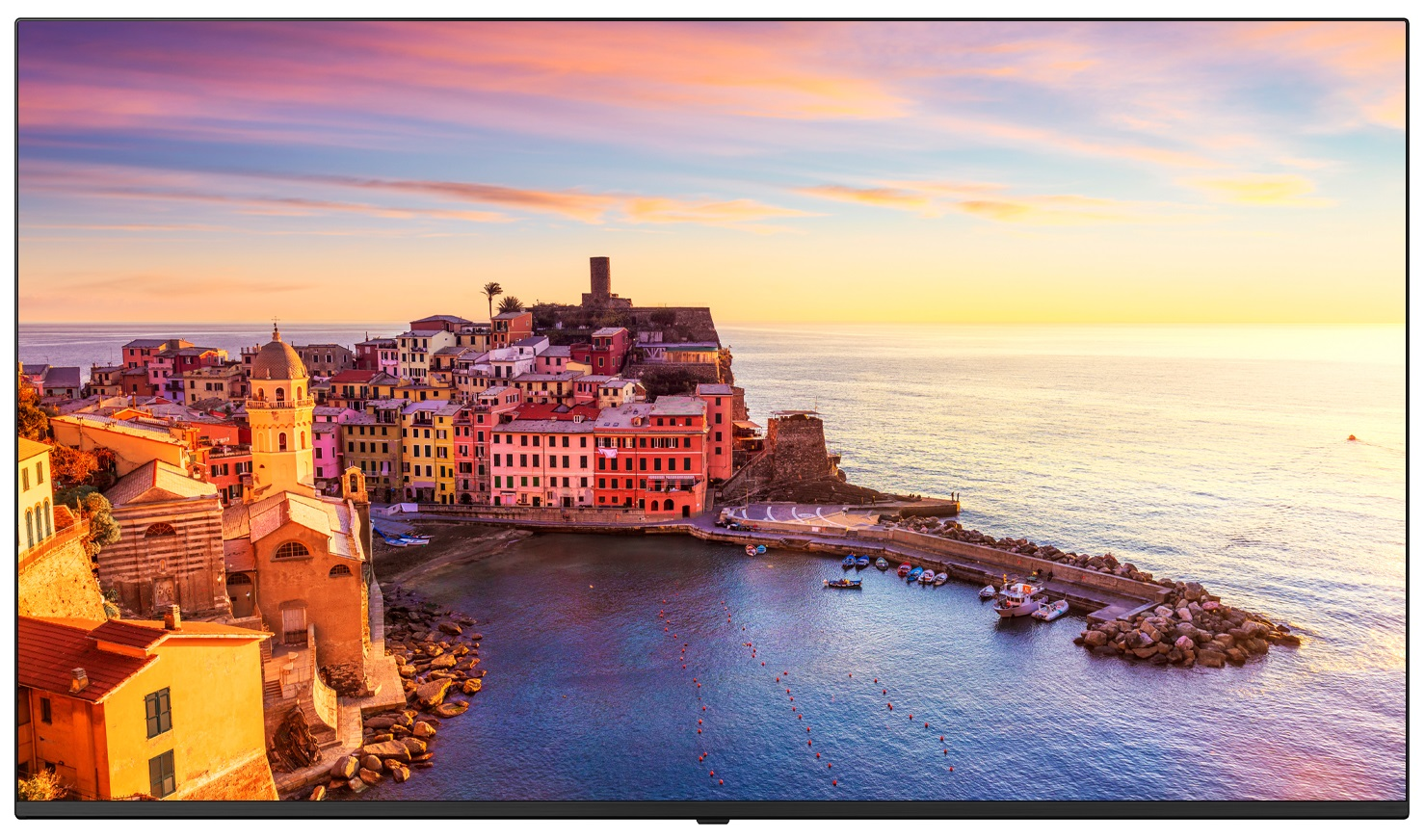 Nadbrzeżne miasto z kolorowymi budynkami. Zachód słońca nad morzem i górami.