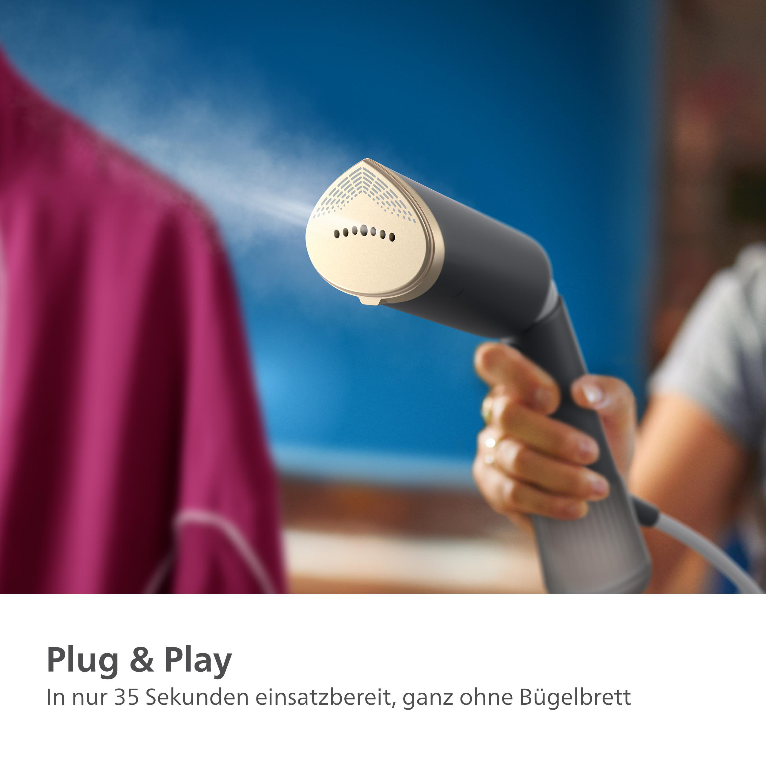 Eine Hand hält einen Kleidungsdampfer über einem rosa Hemd. Dampf kommt aus dem Dampfer heraus.