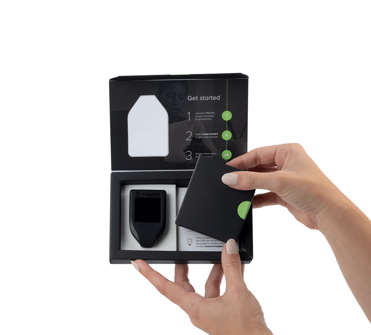 Hände öffnen eine schwarze Box mit einem Trezor Hardware Wallet, weißer Hintergrund.