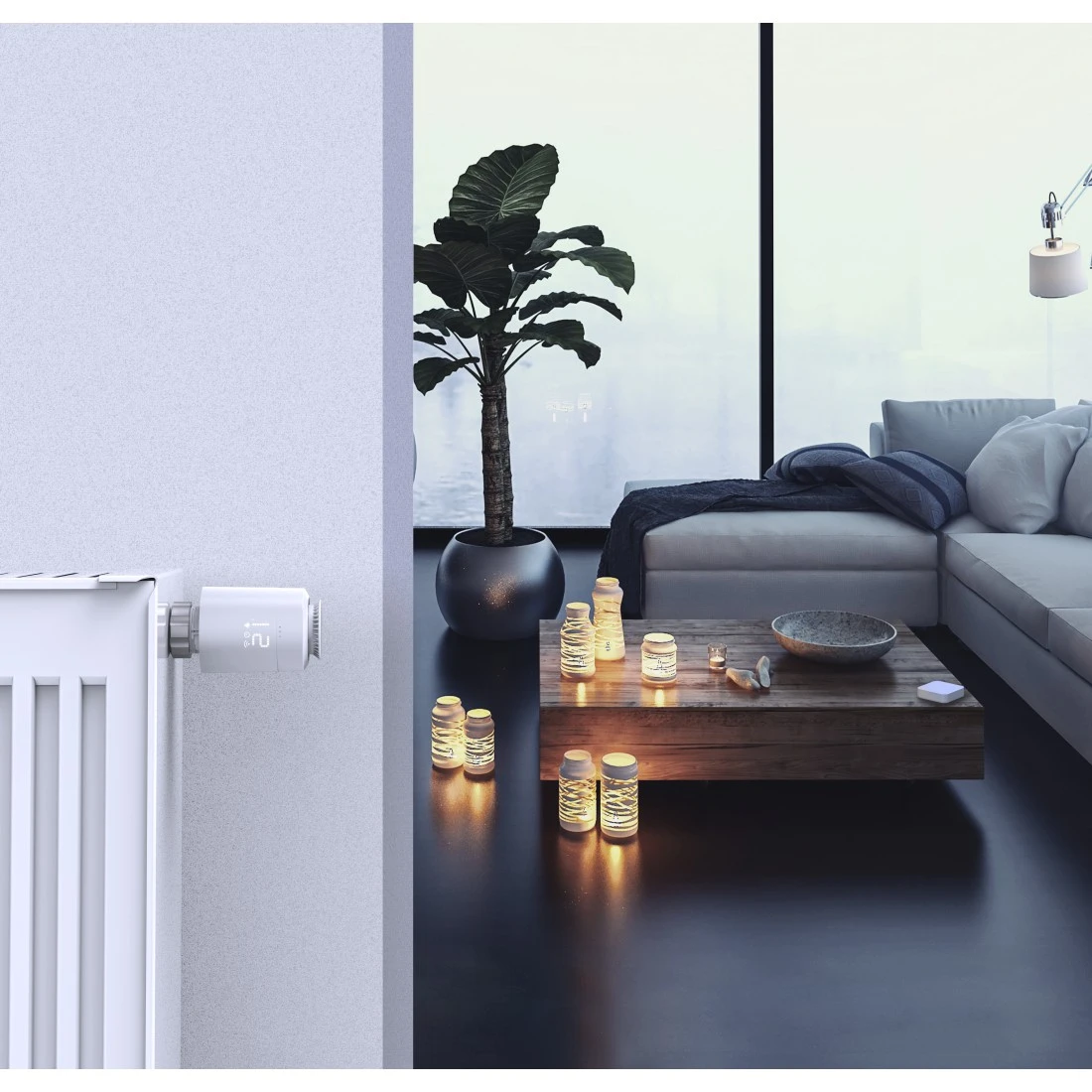 Wohnzimmer mit Pflanze, Kerzen und Heizkörper mit Smart-Thermostat.