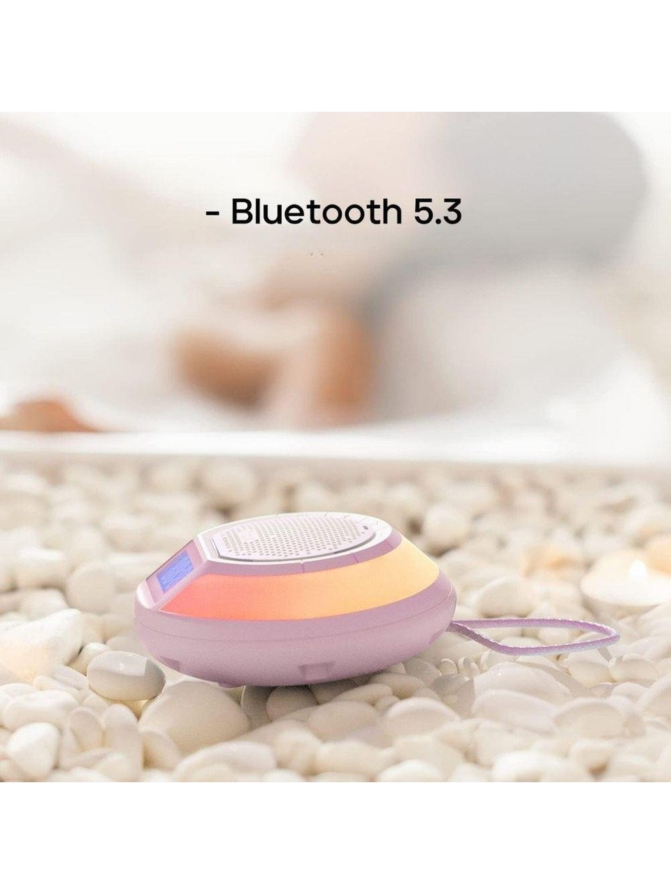 Açık renkli, çakıl taşları üzerinde oval hoparlör, Bluetooth 5.3 yazısı.