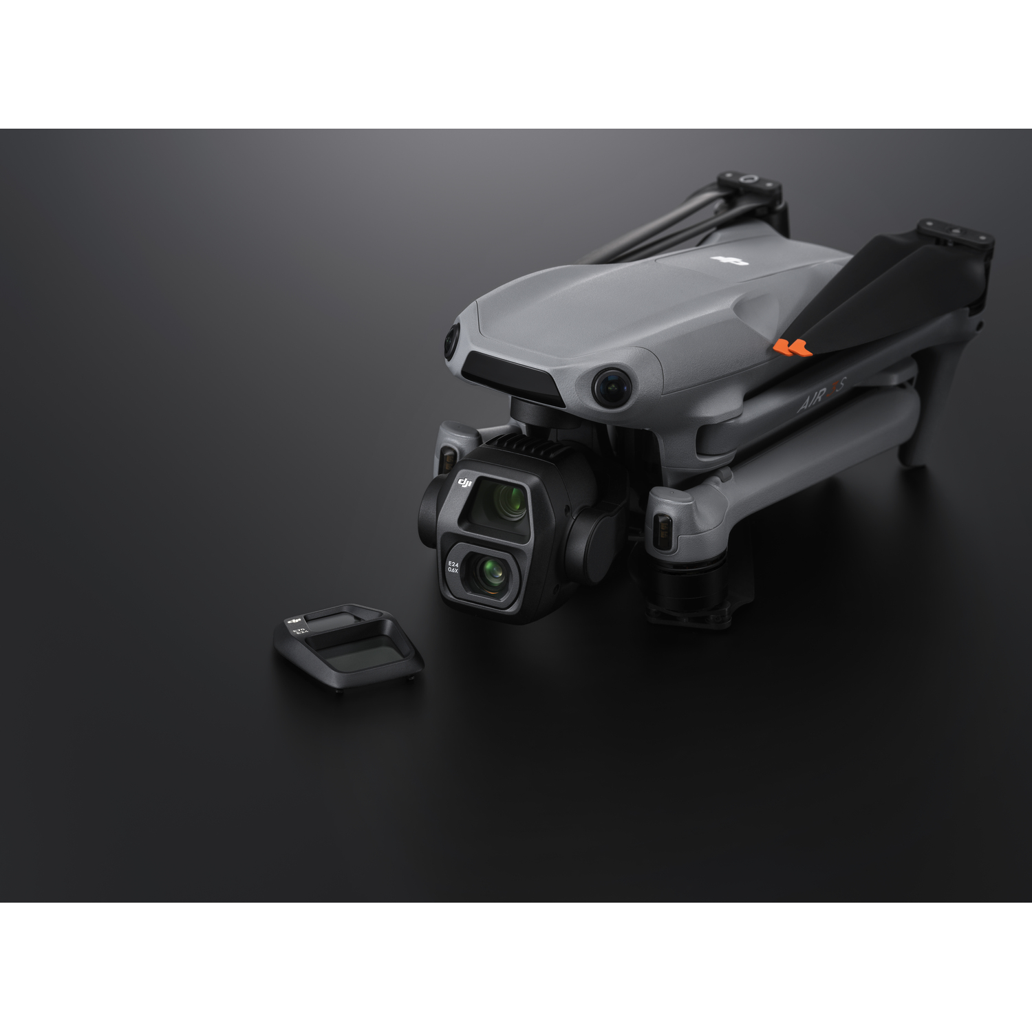 Gray drone with a camera, a lens cover, and a black background.