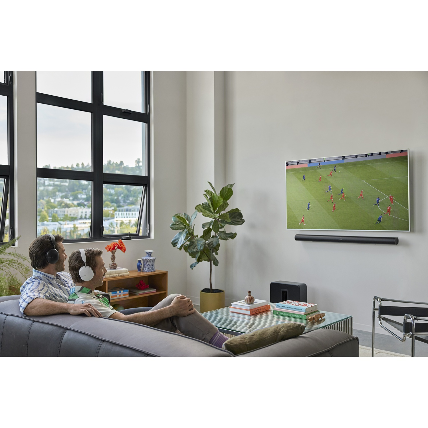 Due persone guardano la TV, con una soundbar e un subwoofer.