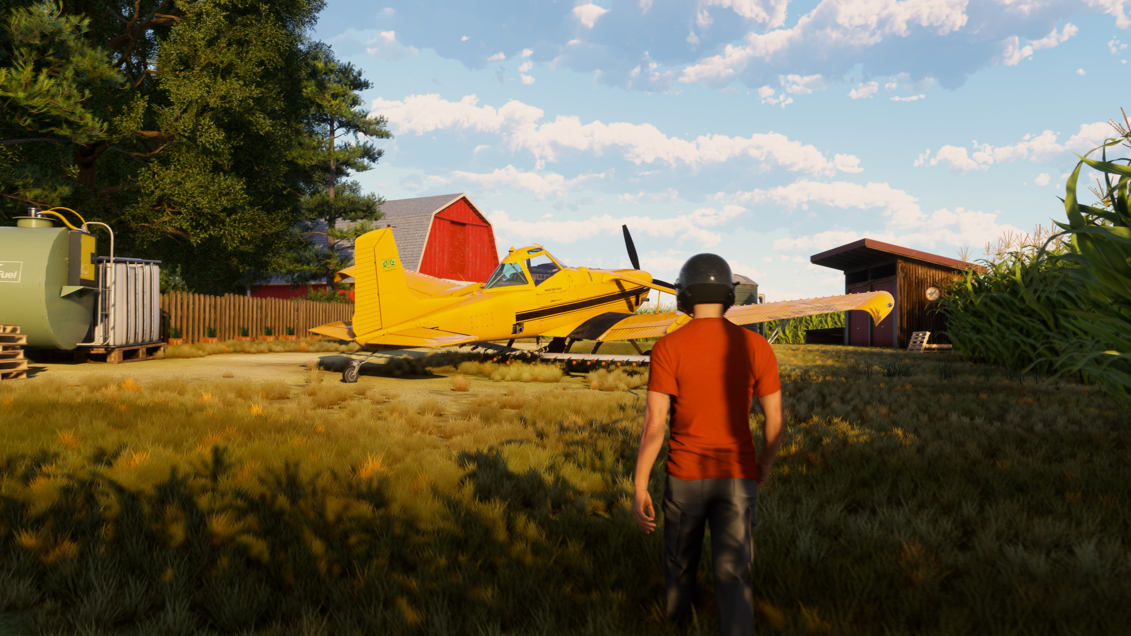 Gelbes Agrarflugzeug auf einer Wiese mit einer Person im Vordergrund.
