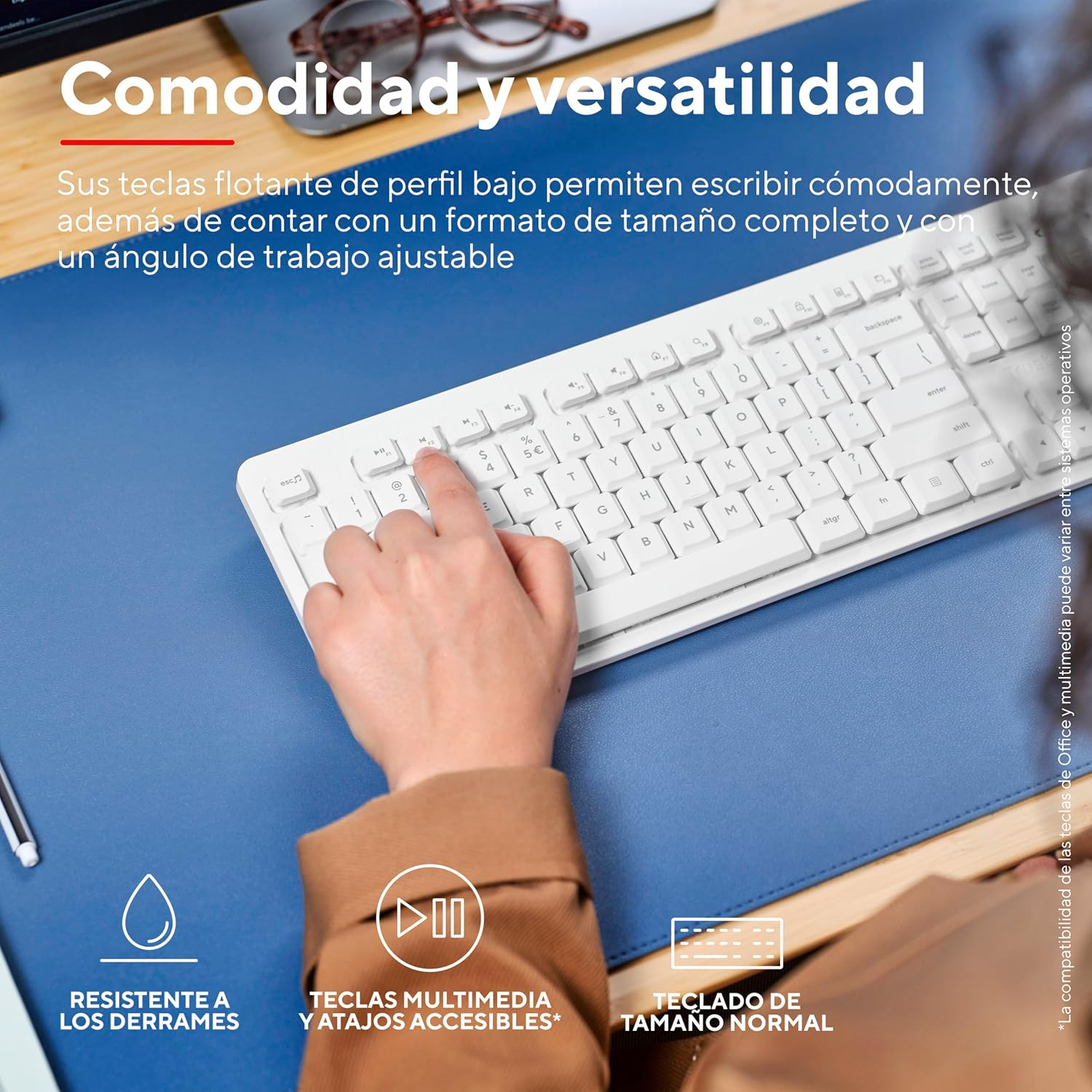 Una mano presiona una tecla en un teclado blanco sobre una alfombrilla azul.
