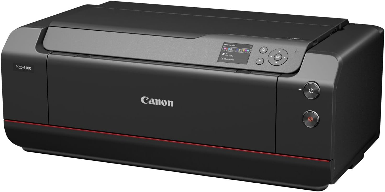Una impresora negra Canon Pro-1100. Tiene una pequeña pantalla, botones de encendido y una franja roja en la parte inferior. Logotipo de Canon visible.
