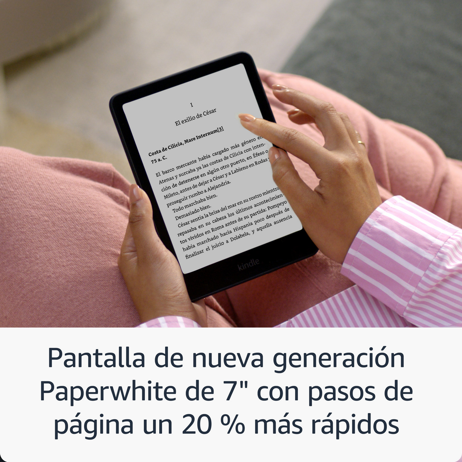 Manos sosteniendo un Kindle con texto. Camisa rosa visible.