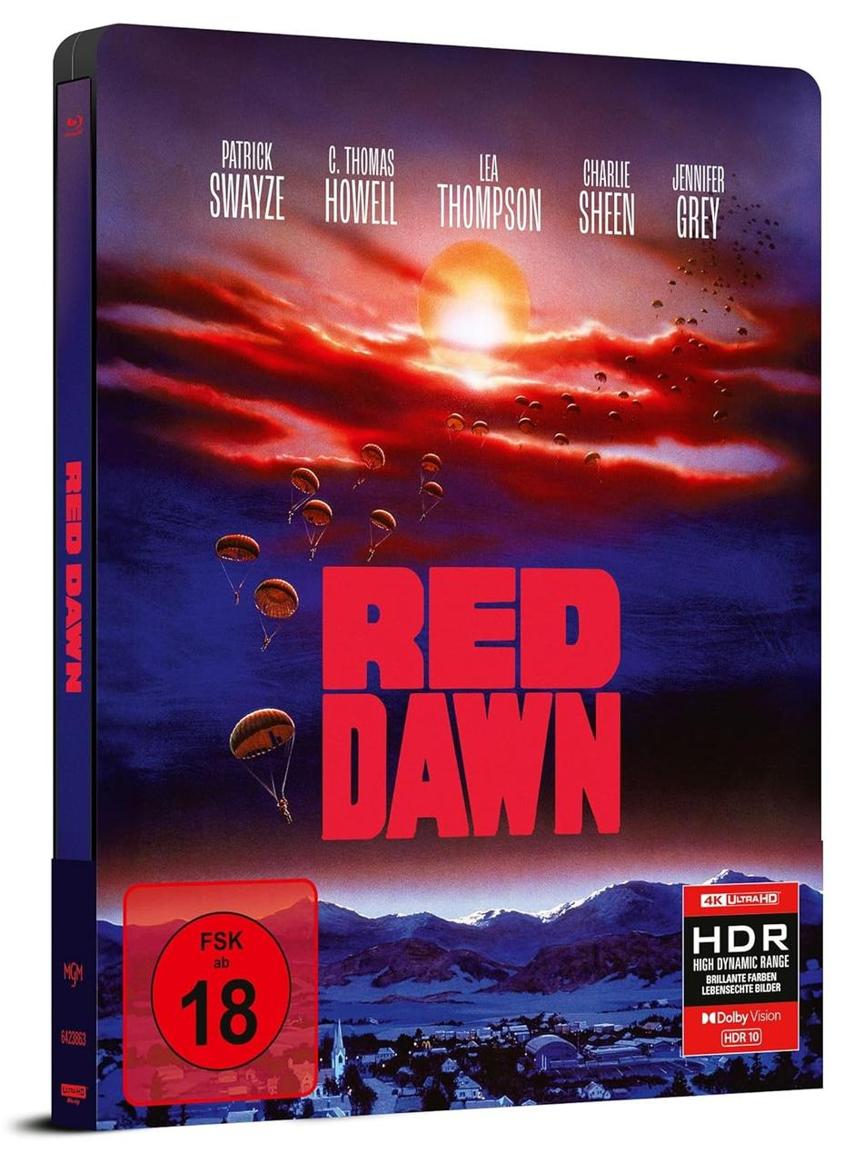 Ein Filmcover für Red Dawn, mit Schauspielern und einer Sonne, die über einer Stadt untergeht.