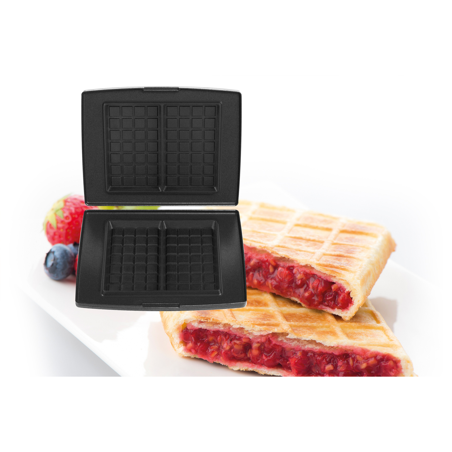 Gaufrier ouvert, gaufres et fruits sur une assiette blanche.