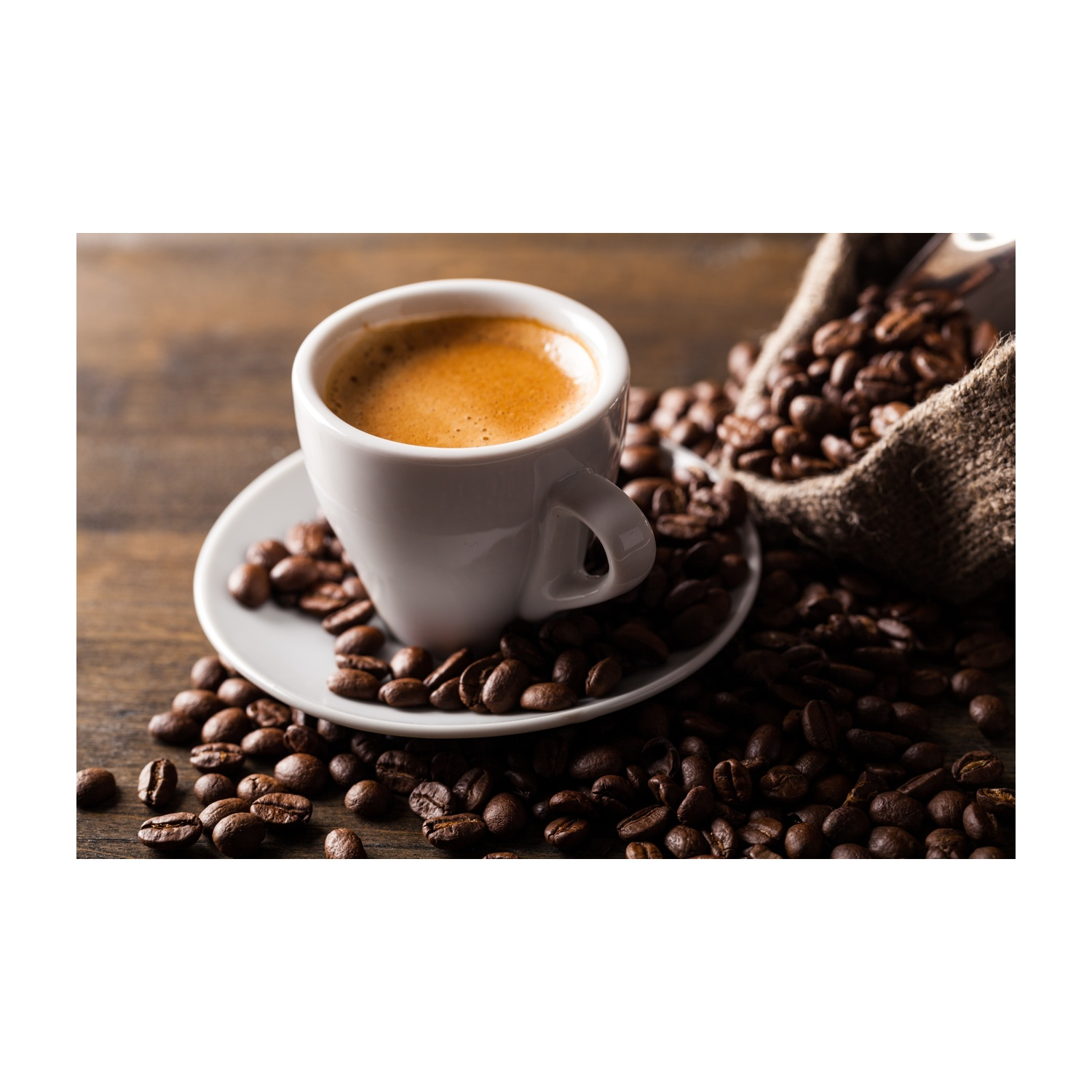 Una tazza bianca di caffè con espresso, circondata da chicchi di caffè su una superficie di legno.