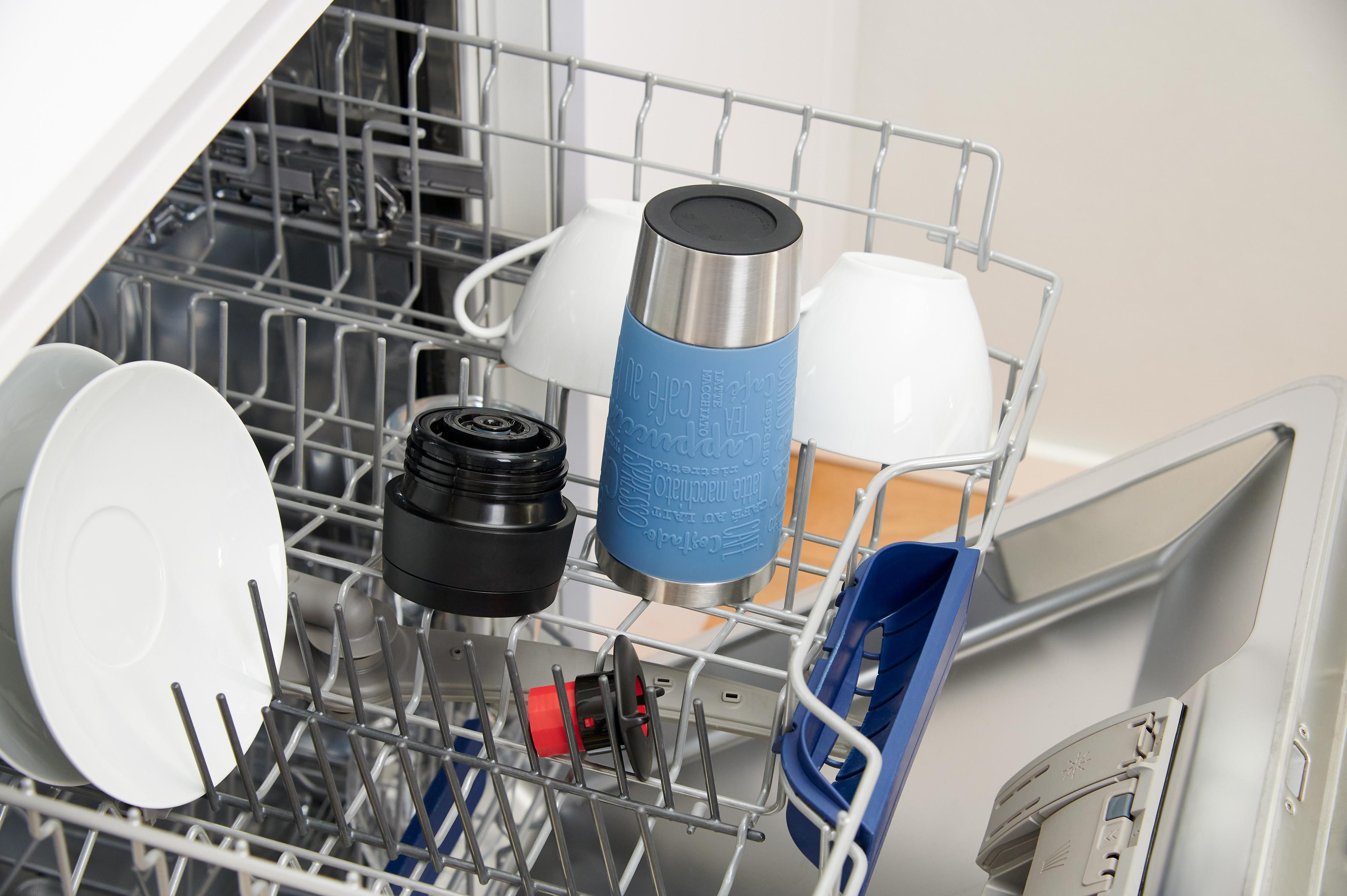 Geschirrspüler mit einem Reisebecher, Tassen und anderen Gegenständen. Der Becher ist blau.