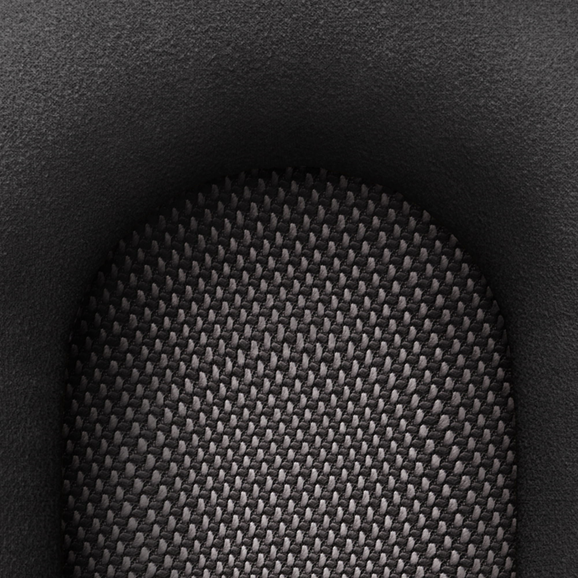 Zbliżenie ciemnej, teksturowanej powierzchni, prawdopodobnie tkaniny głośnikowej.