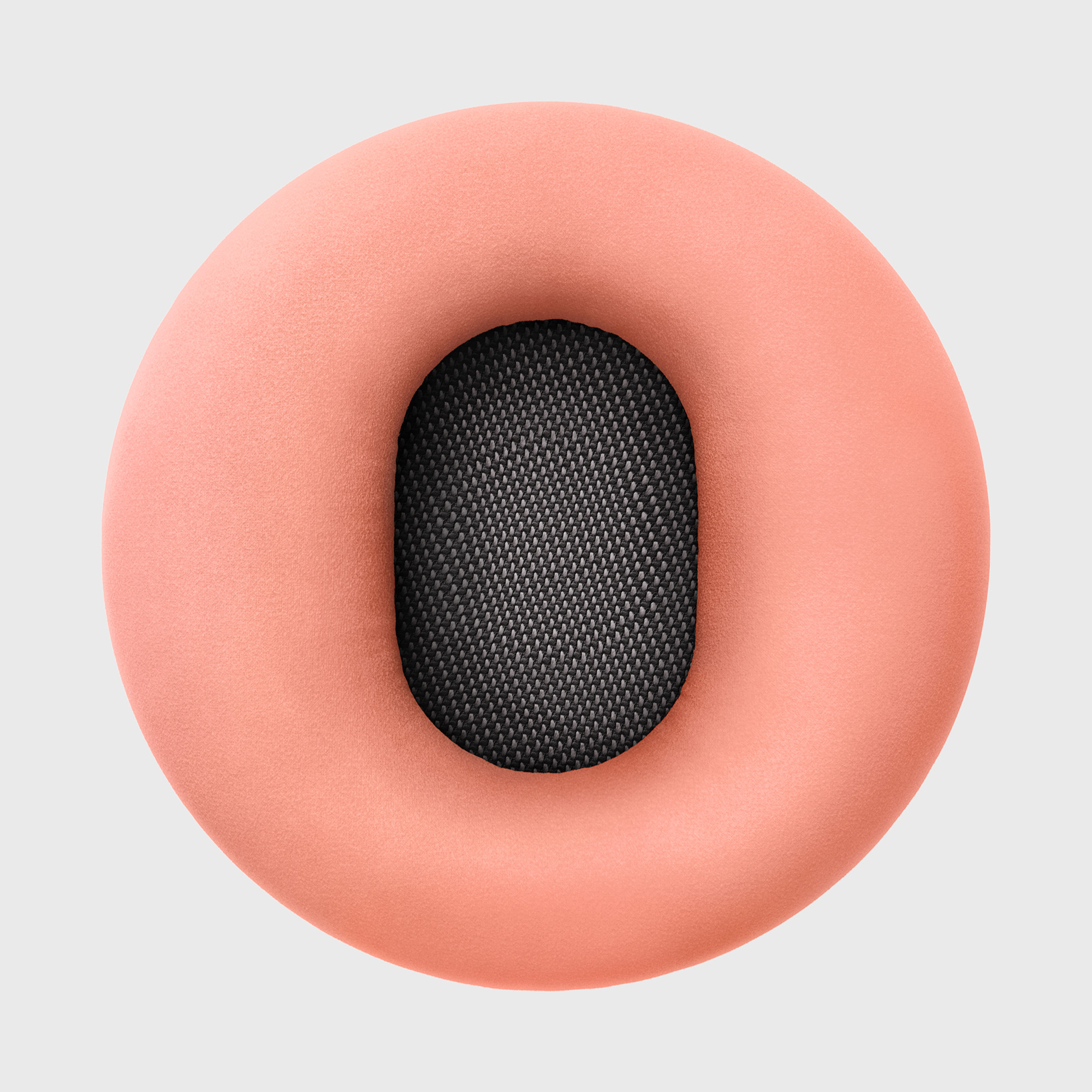 Różowa poduszka na uszy z czarnym, siatkowym środkiem. Na jasnoszarym tle.