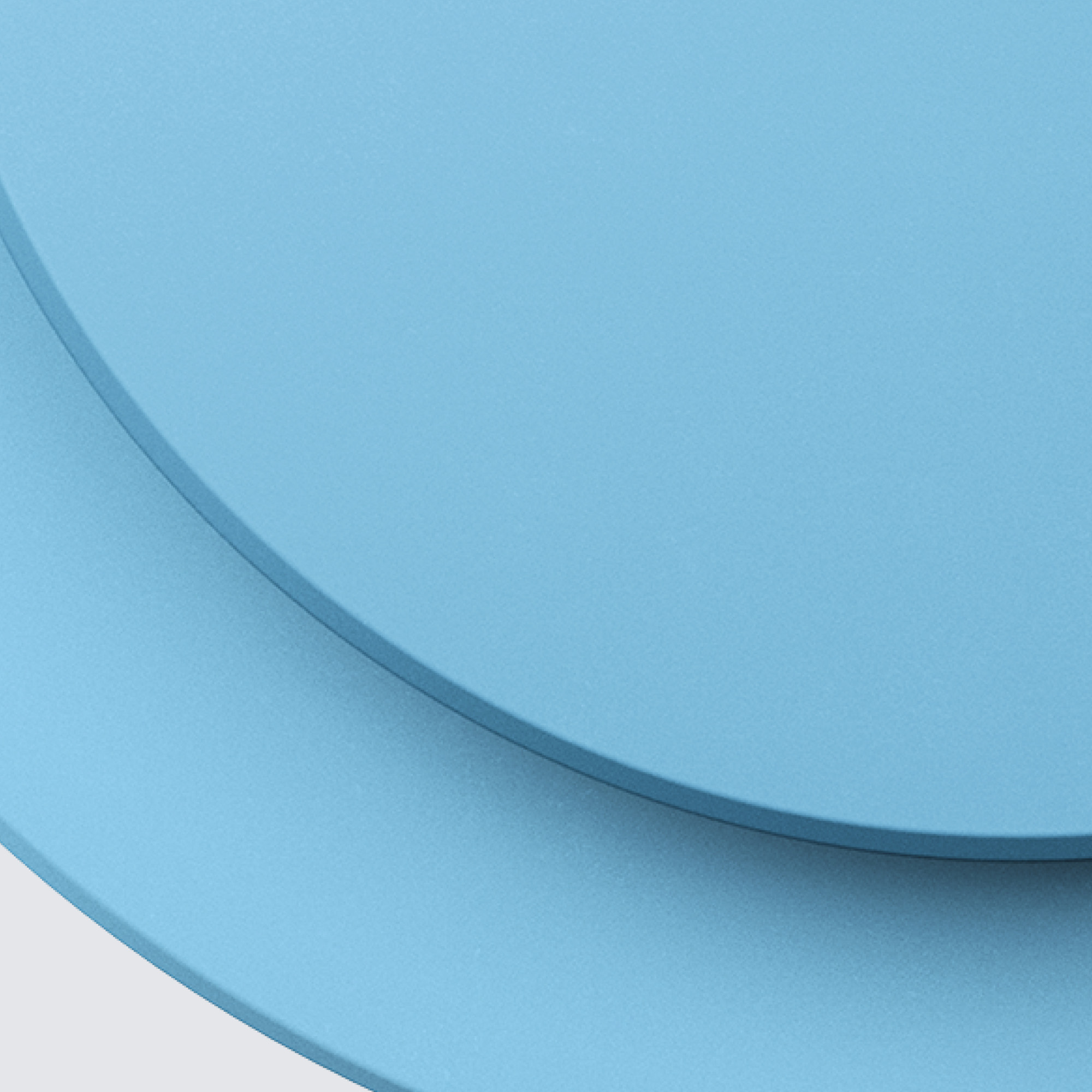 Dwa niebieskie talerze na białej powierzchni. Talerze zachodzą na siebie na dole. Zbliżenie.