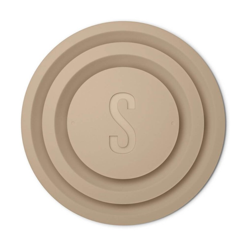 Beżowy, okrągły, warstwowy obiekt z wytłoczoną literą 'S' pośrodku.