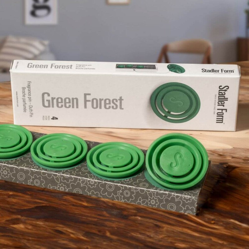 Zielone krążki i pudełko odświeżacza powietrza Green Forest na drewnianym stole.