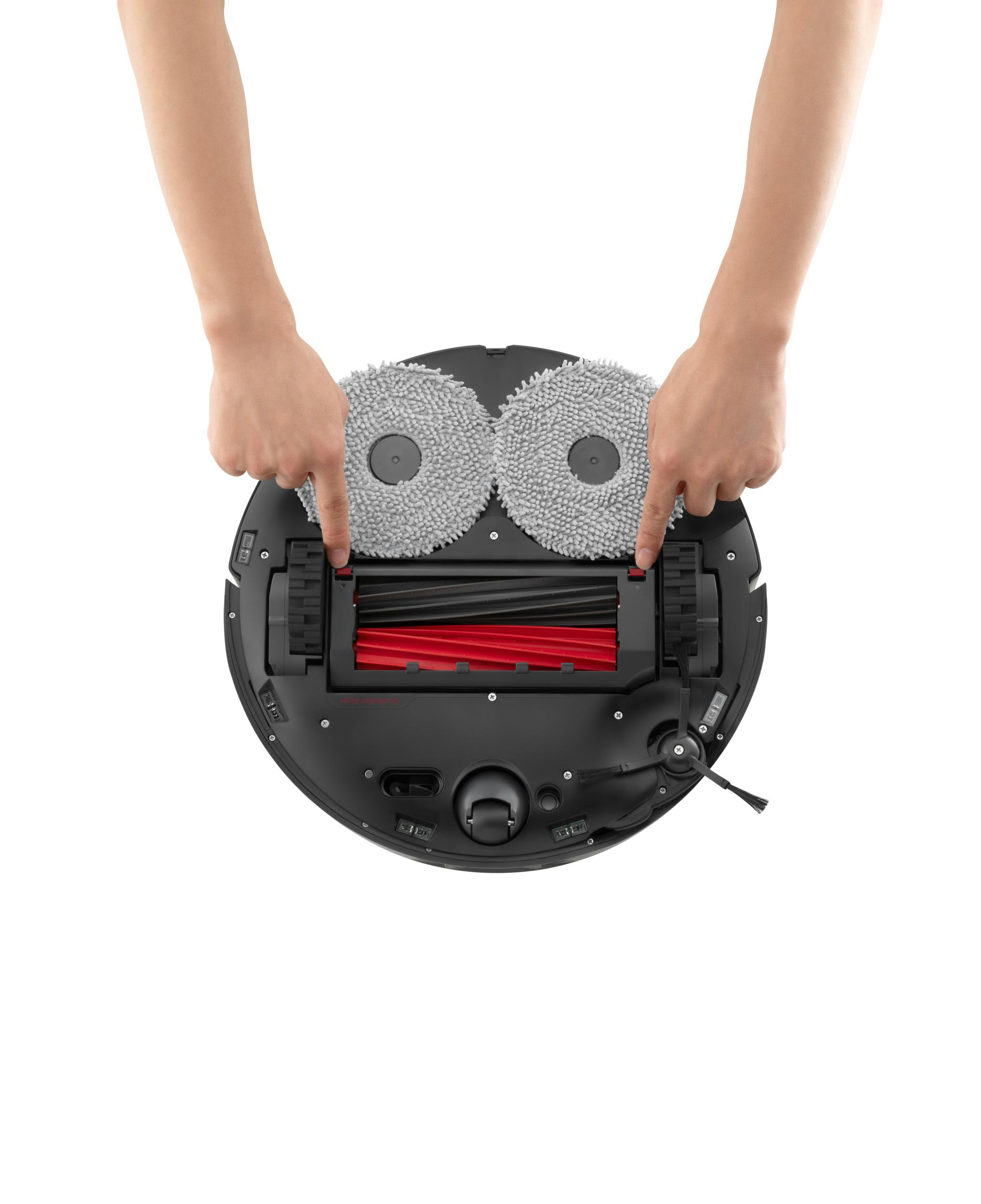 Hände zeigen auf die Unterseite des Roboter-Staubsaugers.