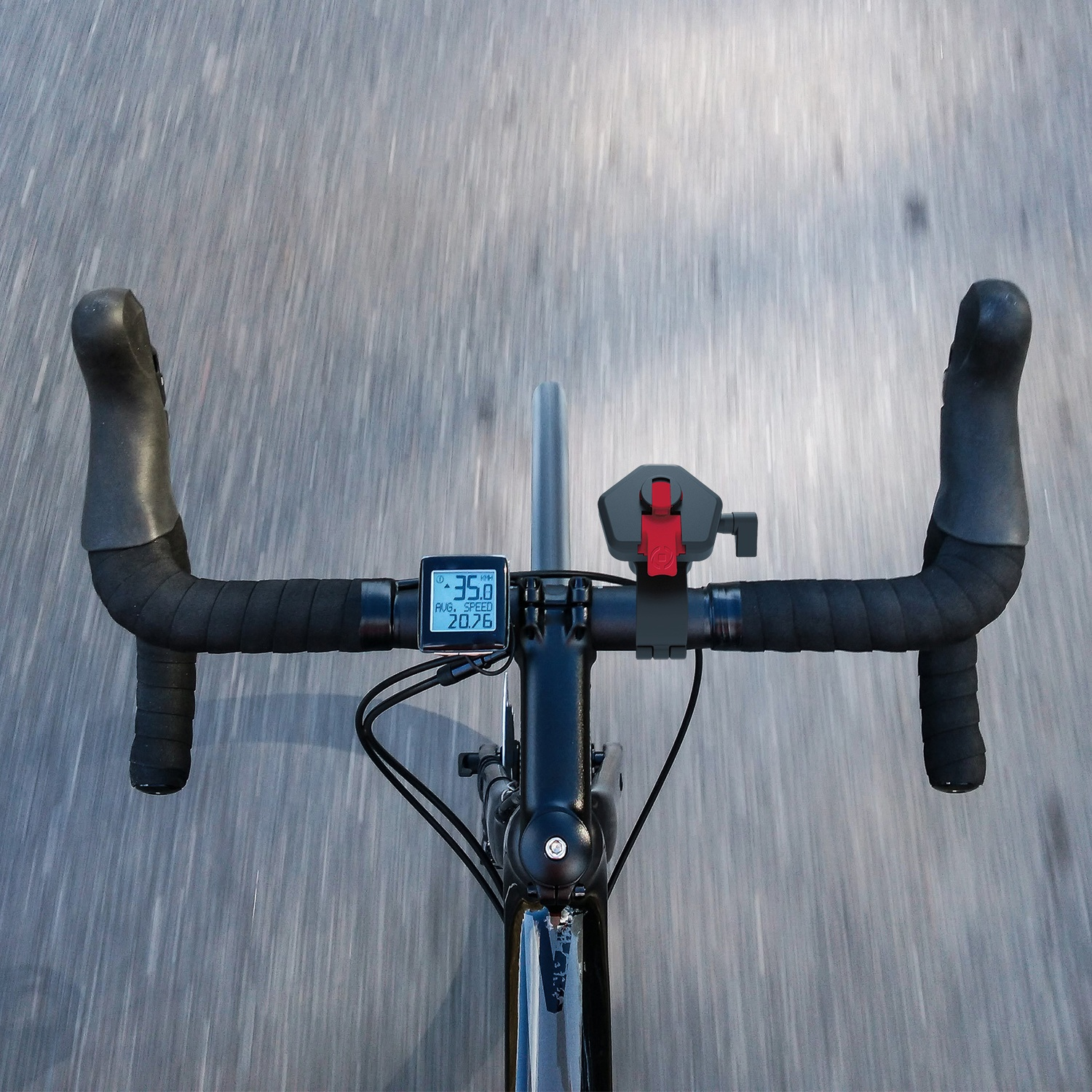 Manubrio di una bicicletta con tachimetro e leva del freno, su una strada sfocata.