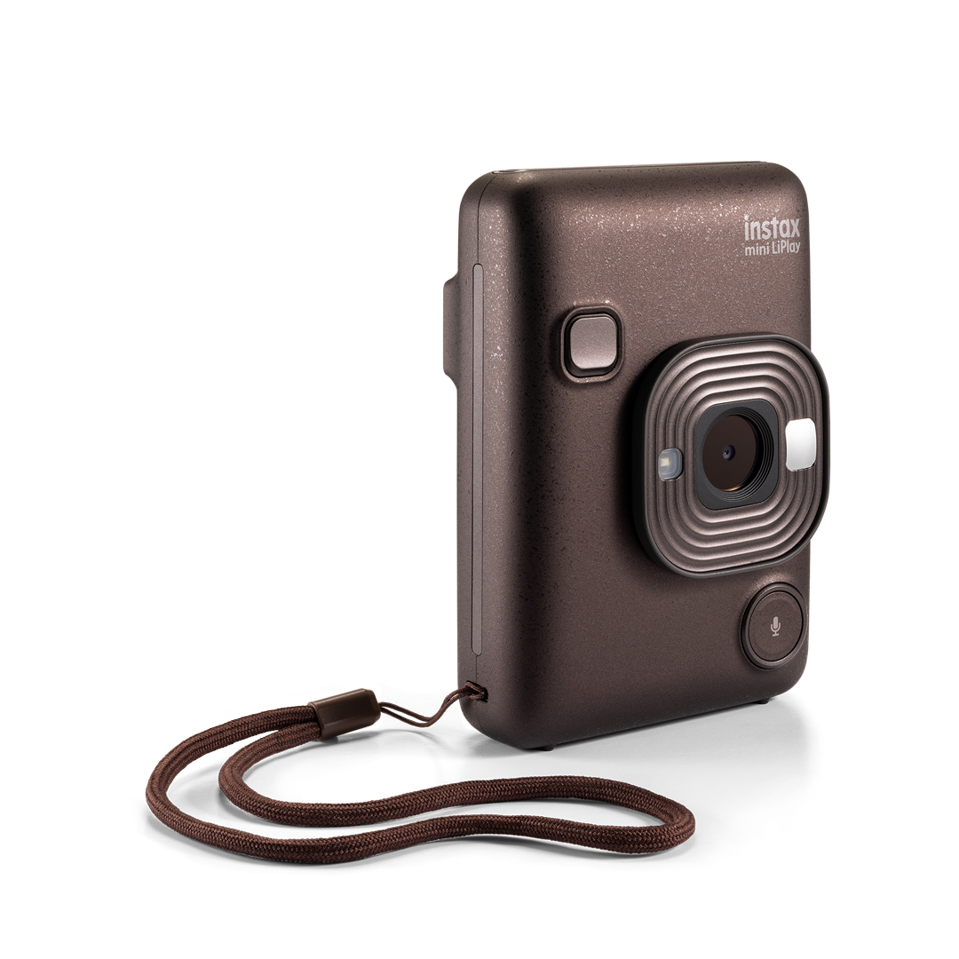 Kahverengi bir Instax Mini LiPlay kamera, kahverengi kayışlı. Ön tarafta bir lens ve bir mikrofon var.