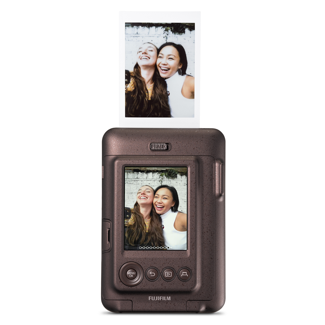 Fotoğraf ve üstte basılı bir resim ile kahverengi bir anında fotoğraf makinesi. İki gülen kadın var.