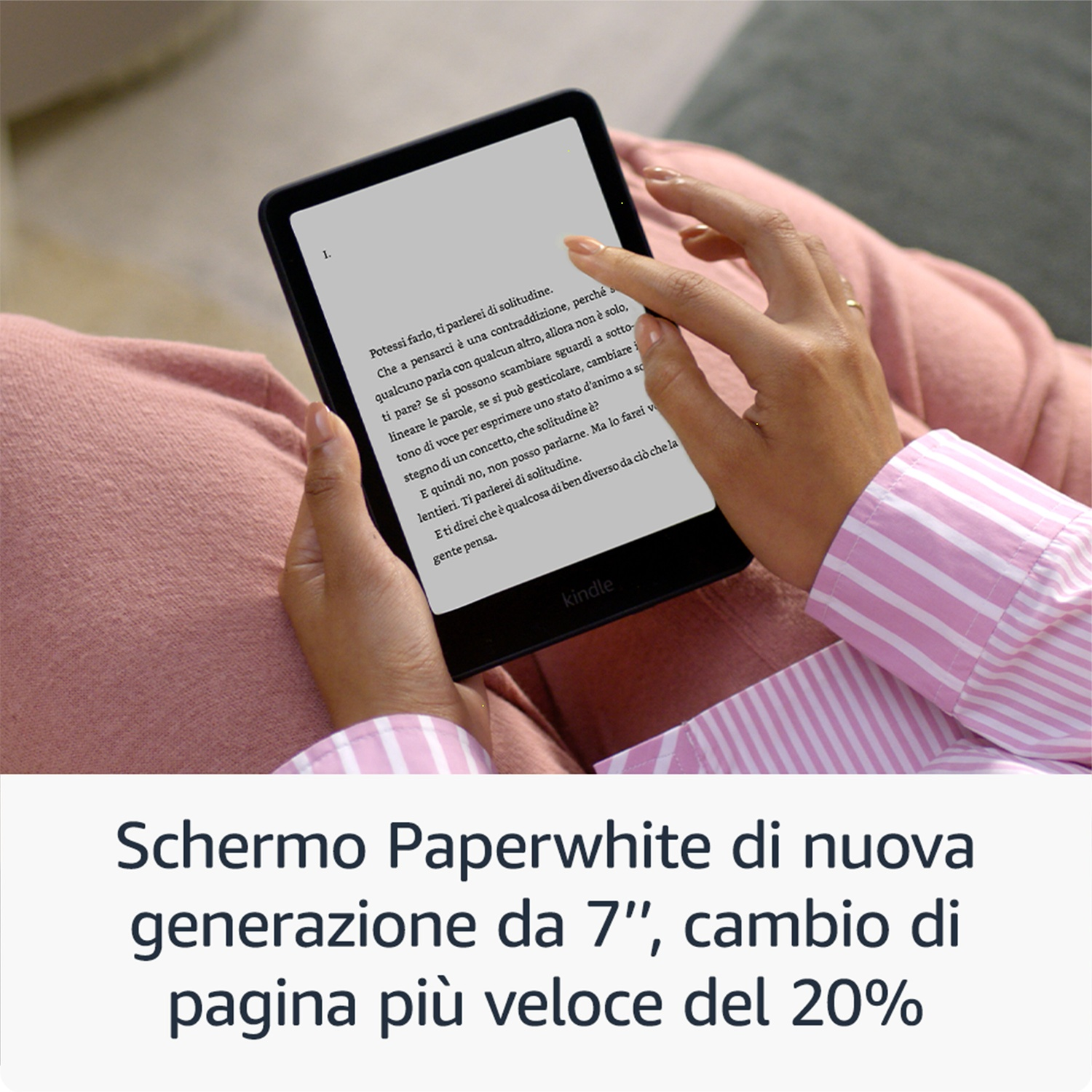 Una persona che tiene un Kindle. Lo schermo mostra del testo. La persona indossa una camicia a righe rosa e bianca.