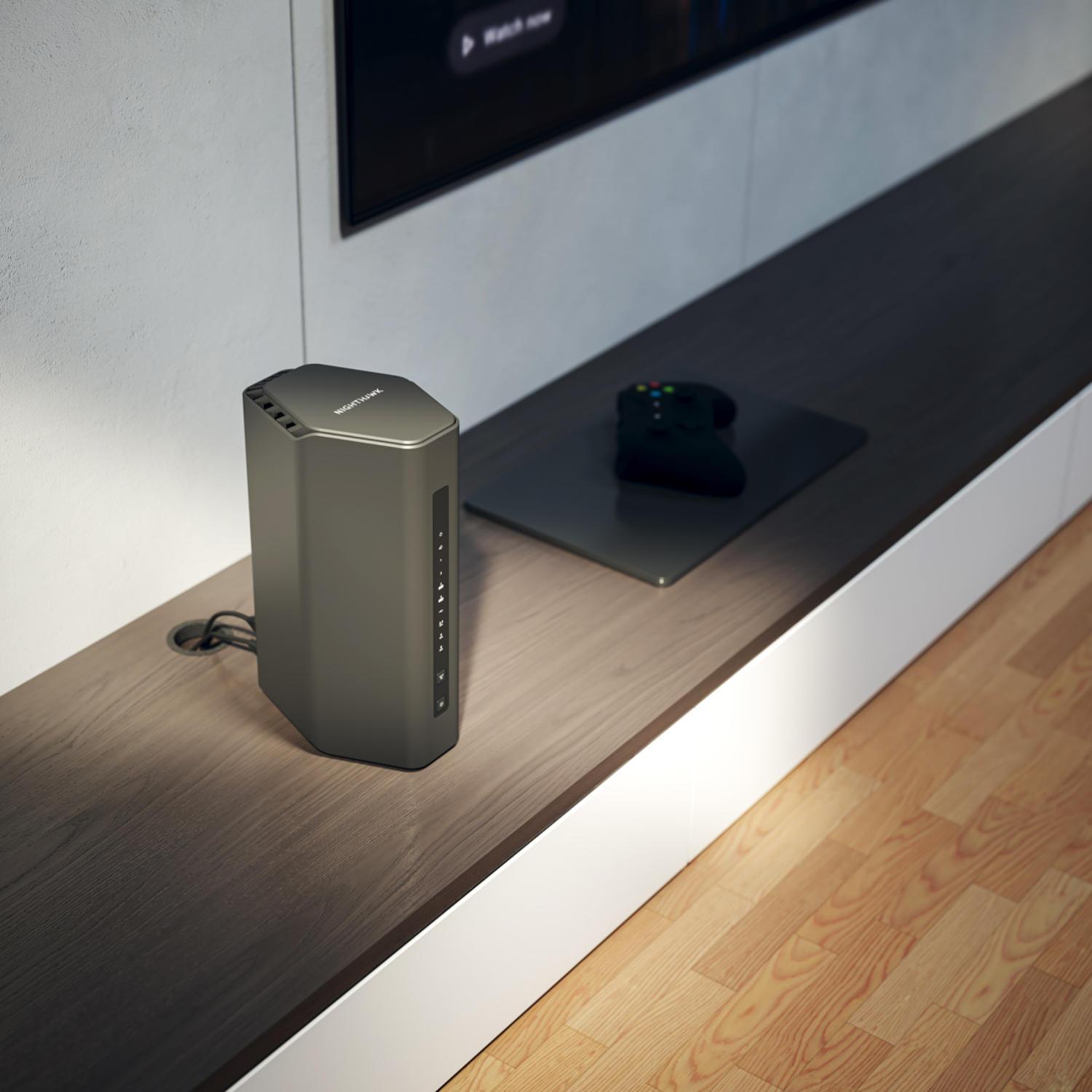 Grijze Nightowl-router op plank, afstandsbediening opzij, tv op achtergrond, houten vloer.