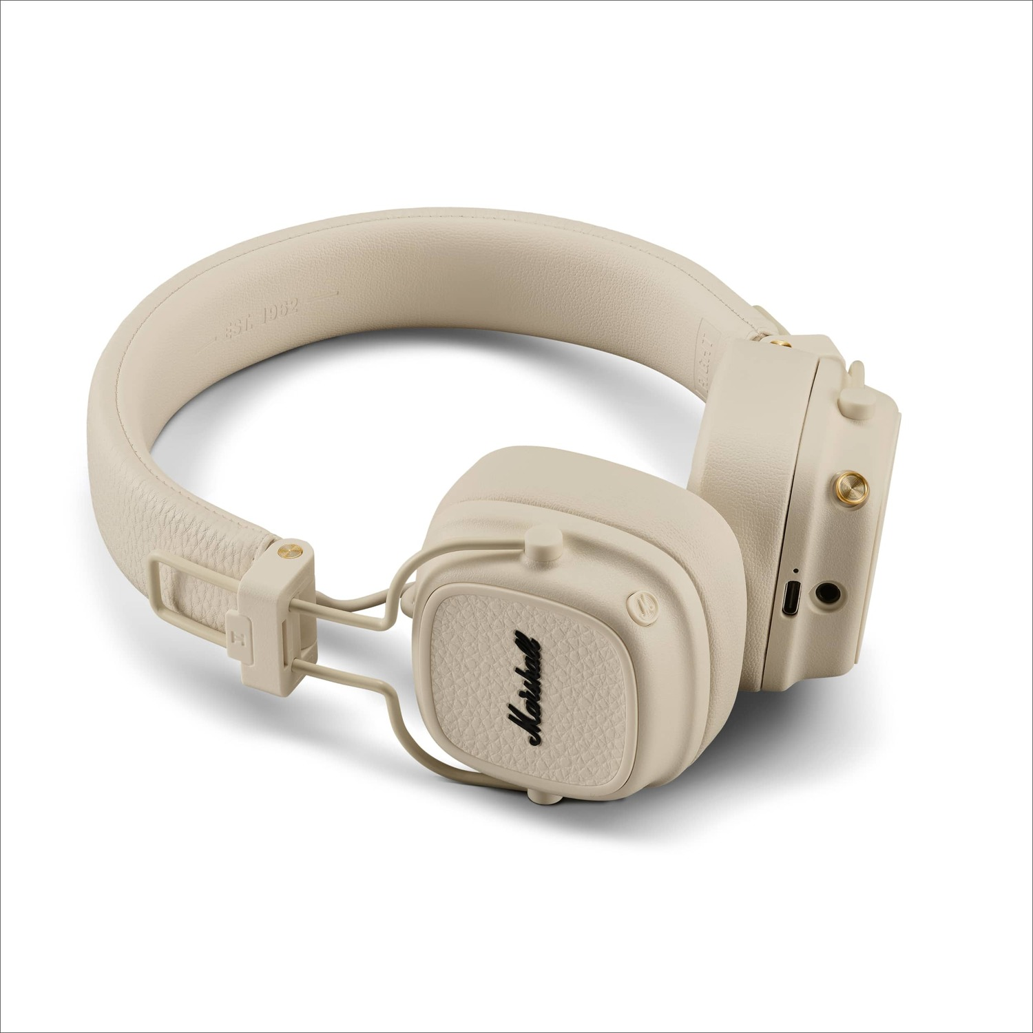 Beige Marshall headphones on a white surface. The headphones have a retro design.