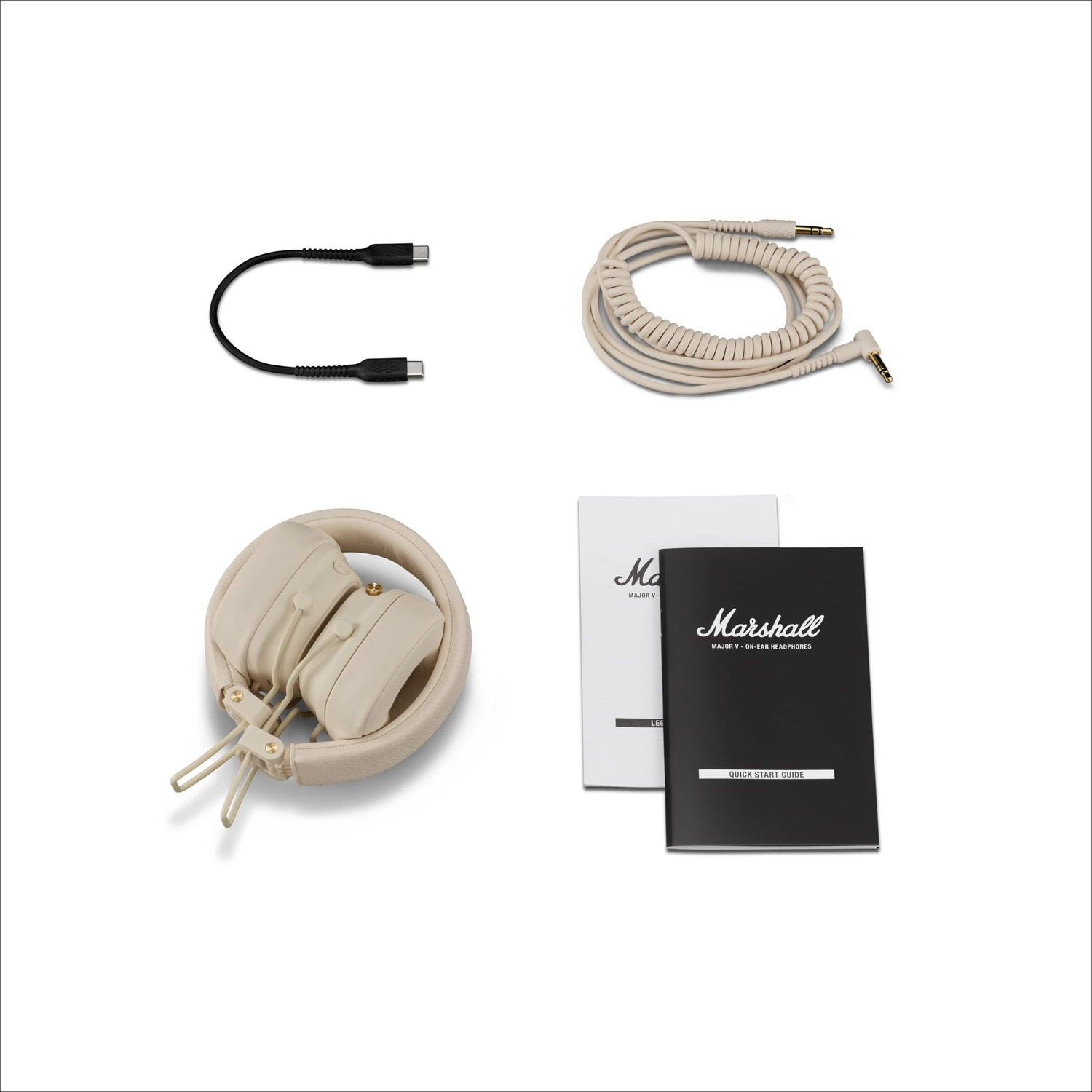 Several items are laid out: a black cable, a beige coiled cable, headphones, and manuals.