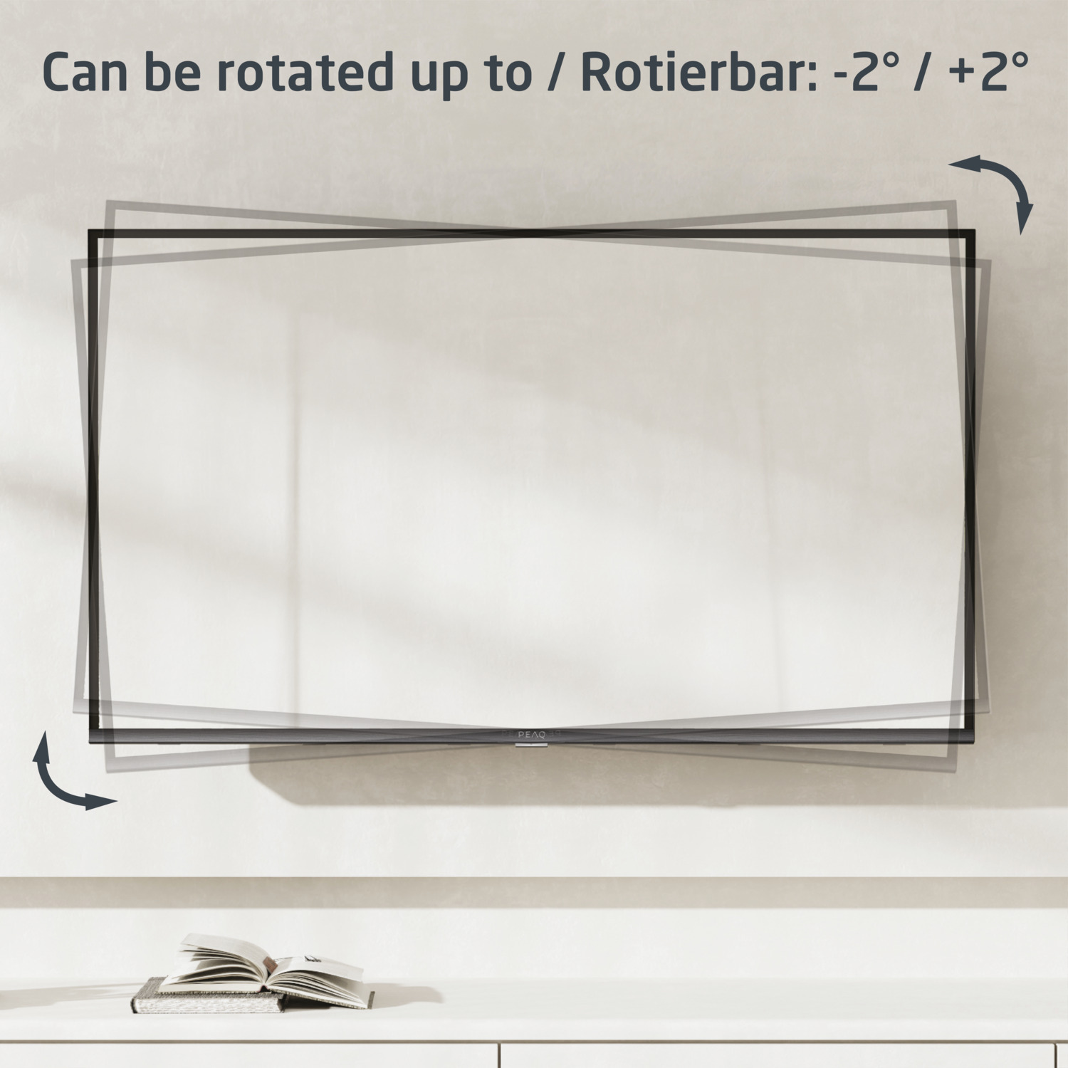 TV montée sur un mur, montrant les angles de rotation, avec un livre ouvert sur une surface blanche.