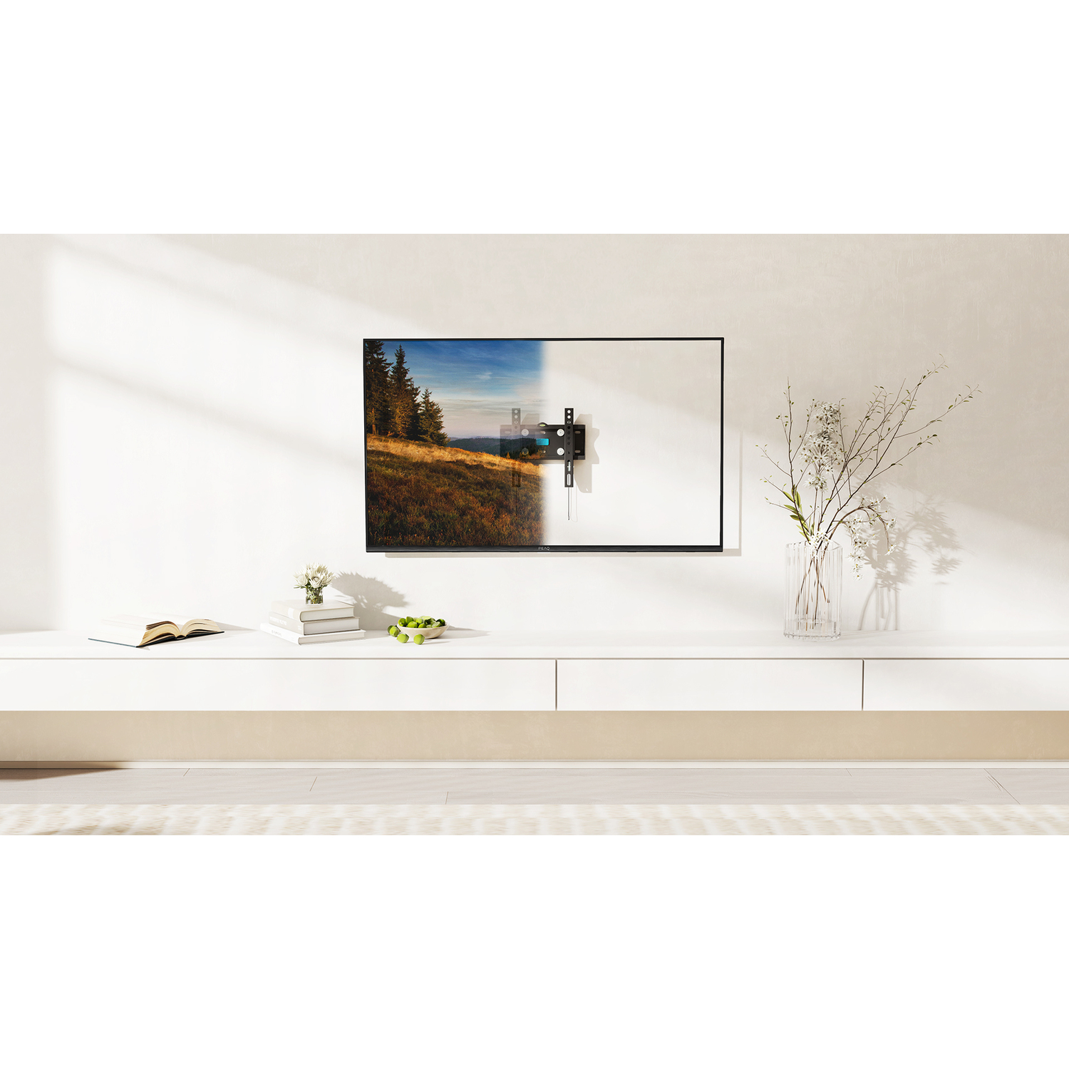 Tv aan witte muur, landschapsbeeld op scherm, witte plank met boeken en bloemen.