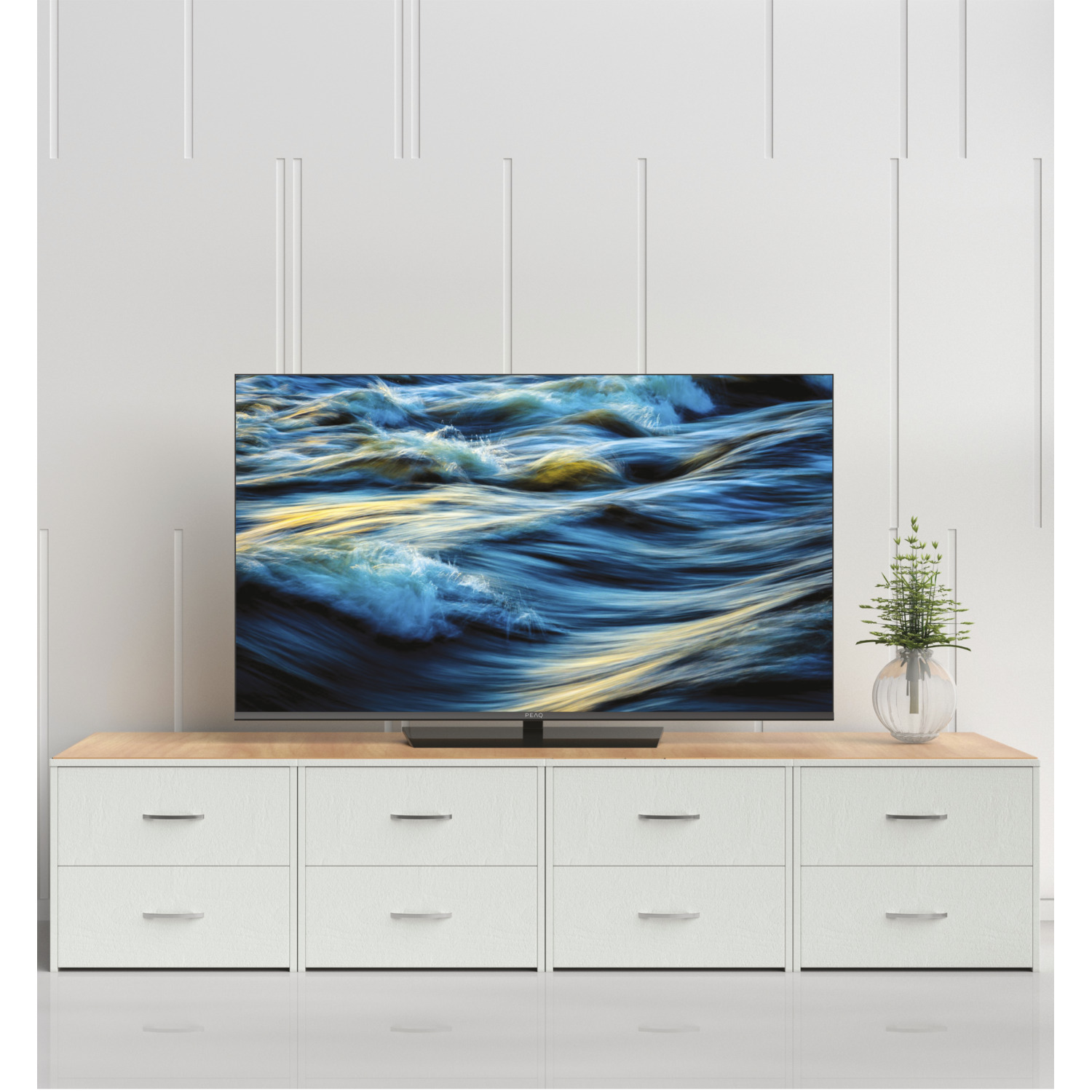 Tv op een standaard met blauwe oceaangolven. Witte laden eronder, witte muurachtergrond.