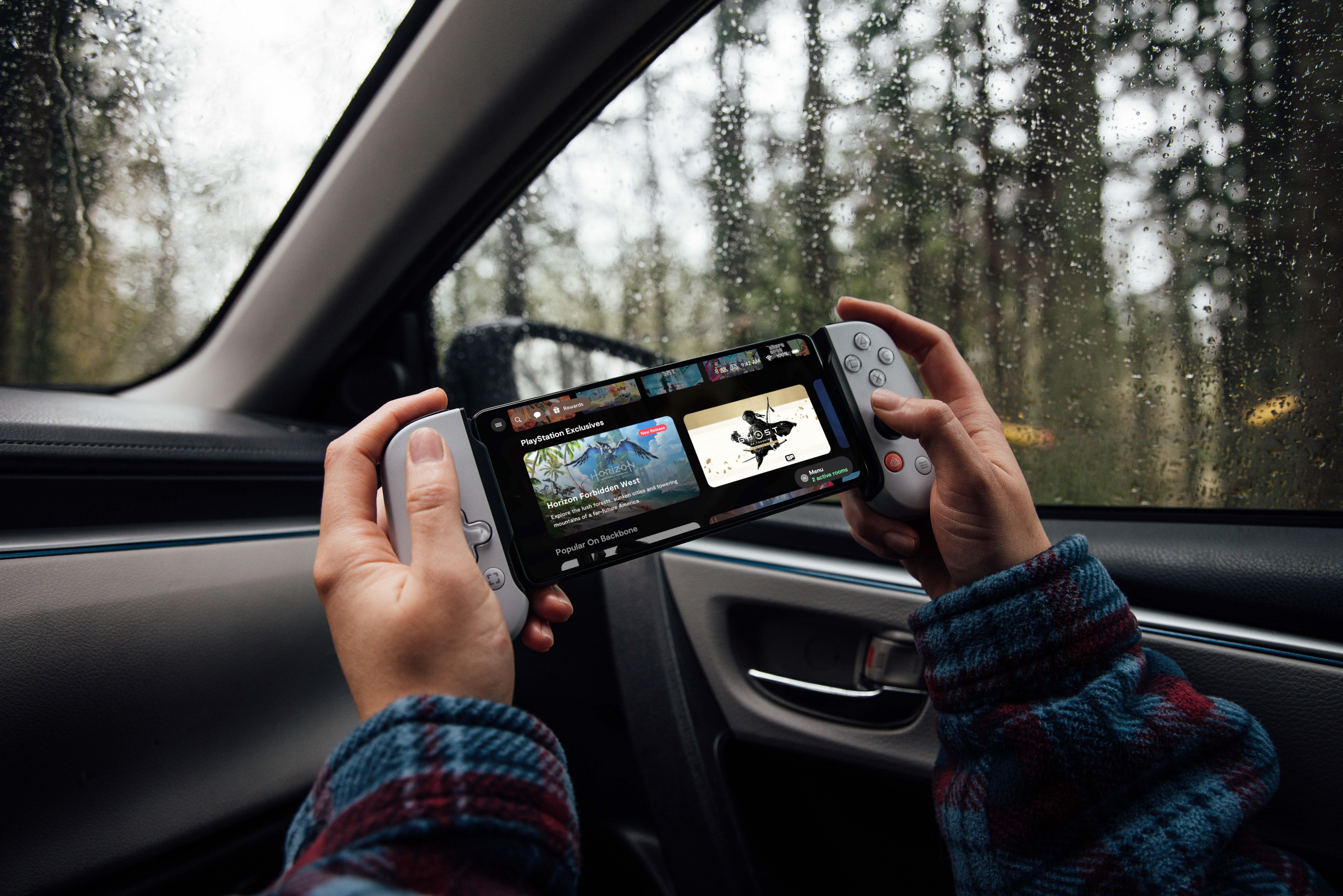 Hände, die ein Spielgerät in einem Auto halten.