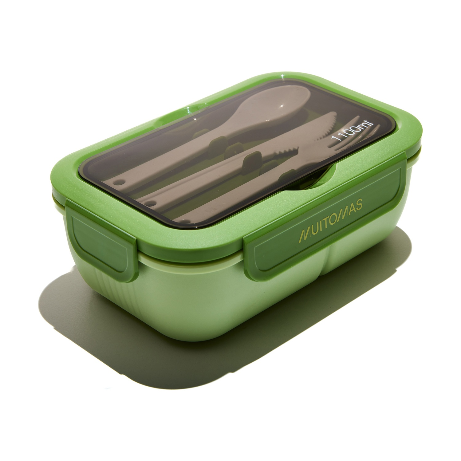 Lunch box verde con utensili all'interno. Il coperchio è trasparente. È su sfondo bianco.