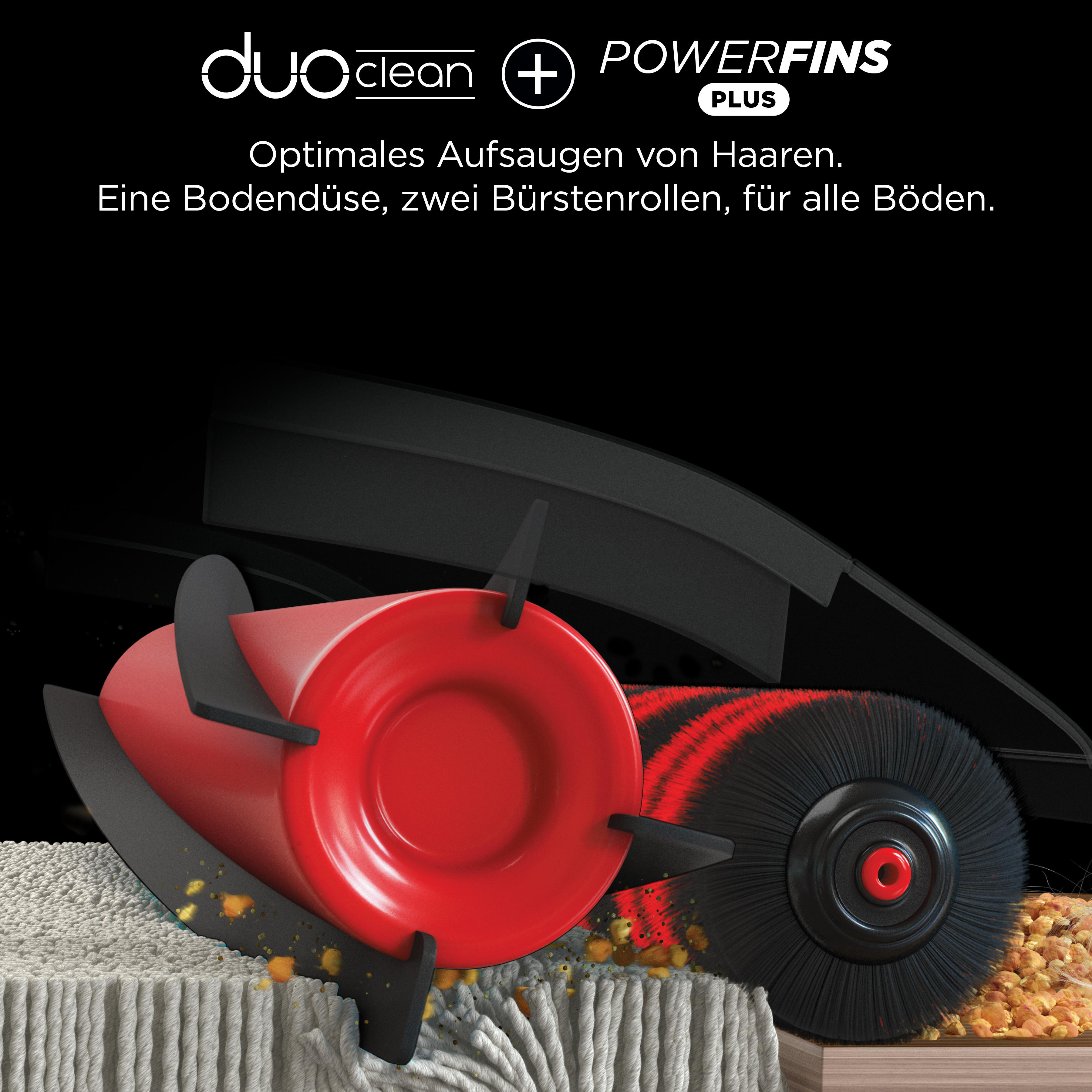 Nahaufnahme eines Staubsaugerkopfes mit roten und schwarzen Bürsten, auf Stoff.