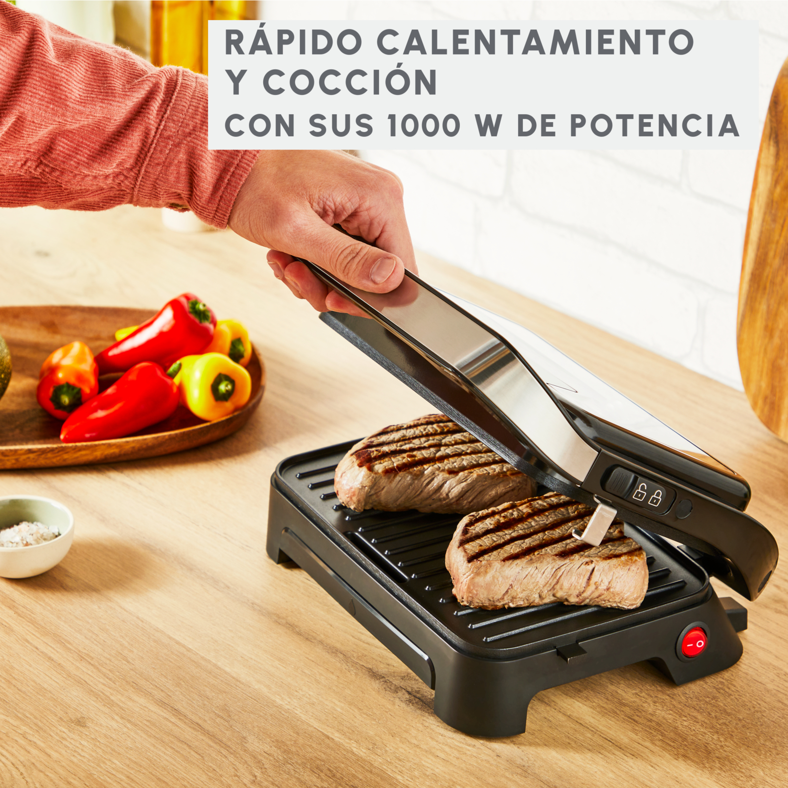 Persona asando filetes en una parrilla negra. Texto: Calentamiento y cocción rápidos.