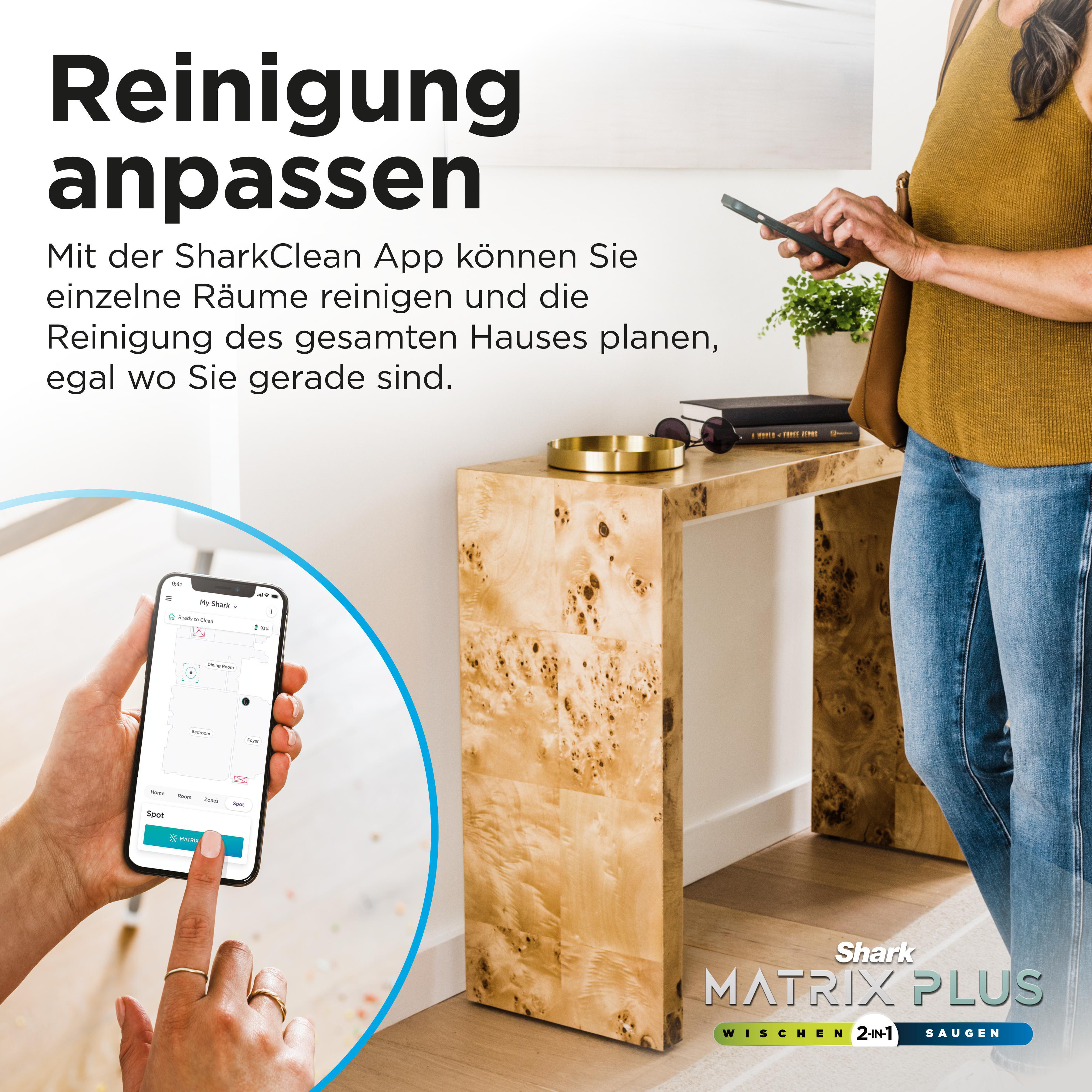 Eine Frau benutzt ein Telefon in der Nähe eines Tisches. Der Text lautet: Reinigung anpassen. Unten steht Shark Matrix Plus.