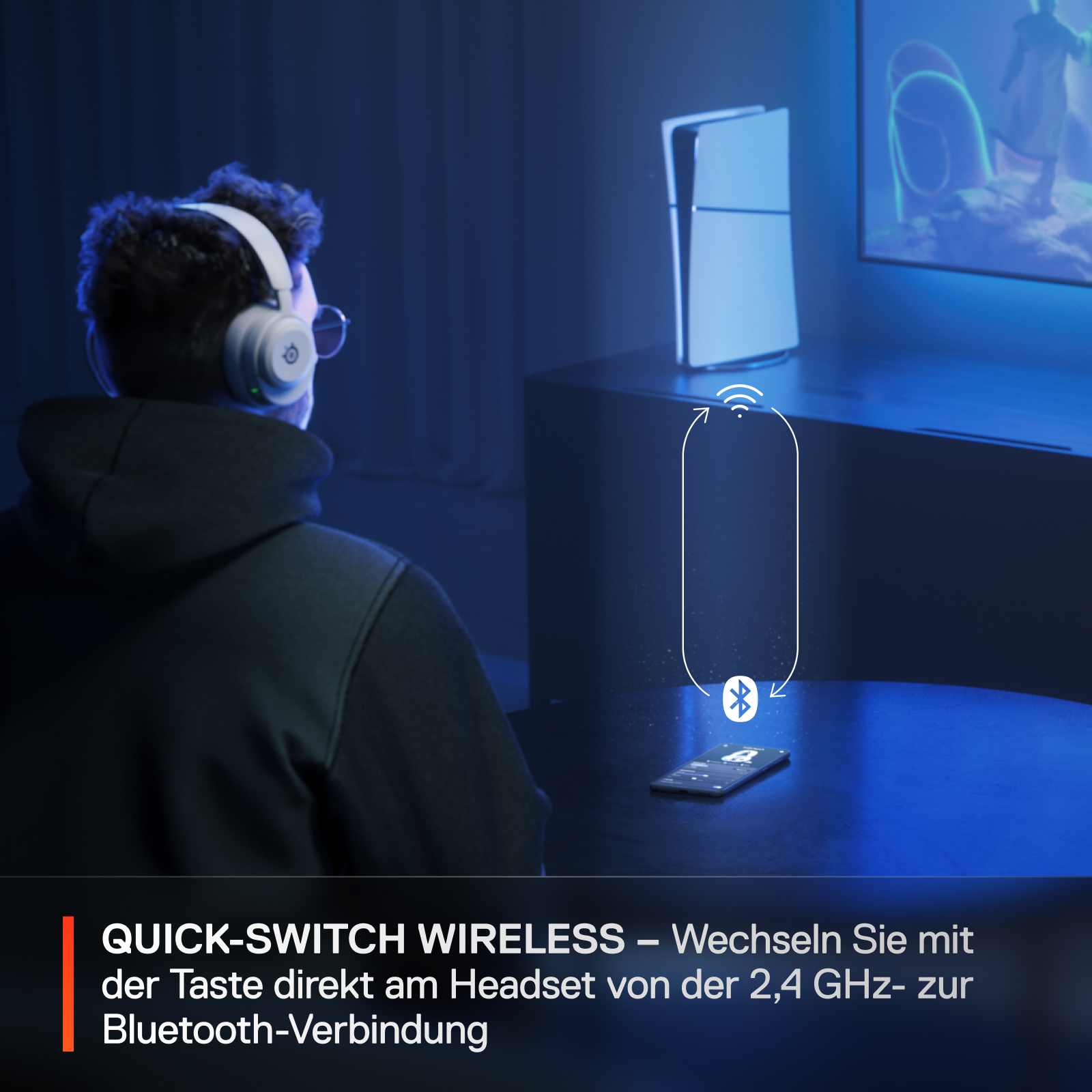 Person mit Kopfhörern, blickt auf Bildschirm. Telefon und Konsole liegen auf einem Tisch.