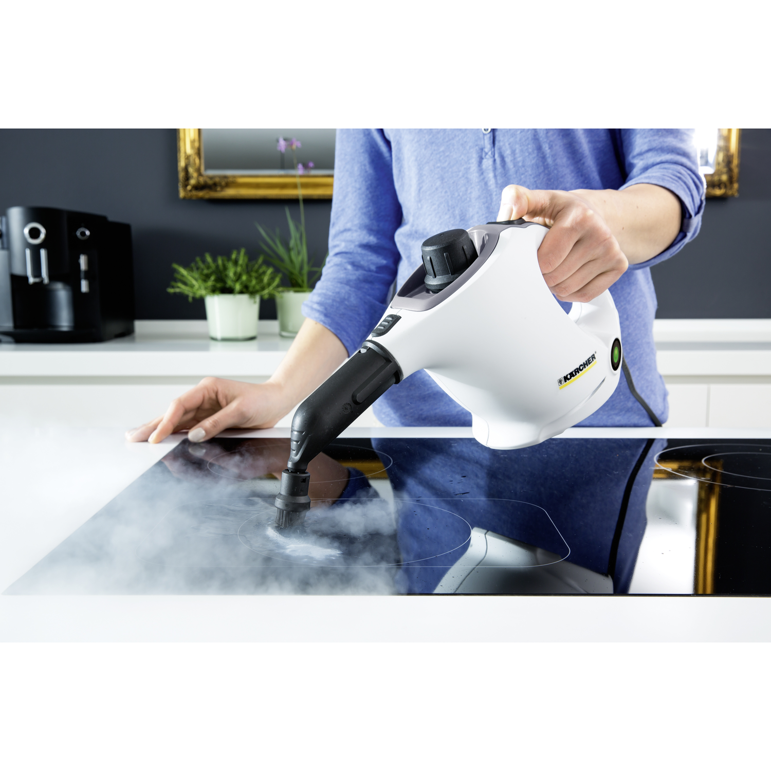 Woman cleaning hob with white steamer. White hob, black steamer.