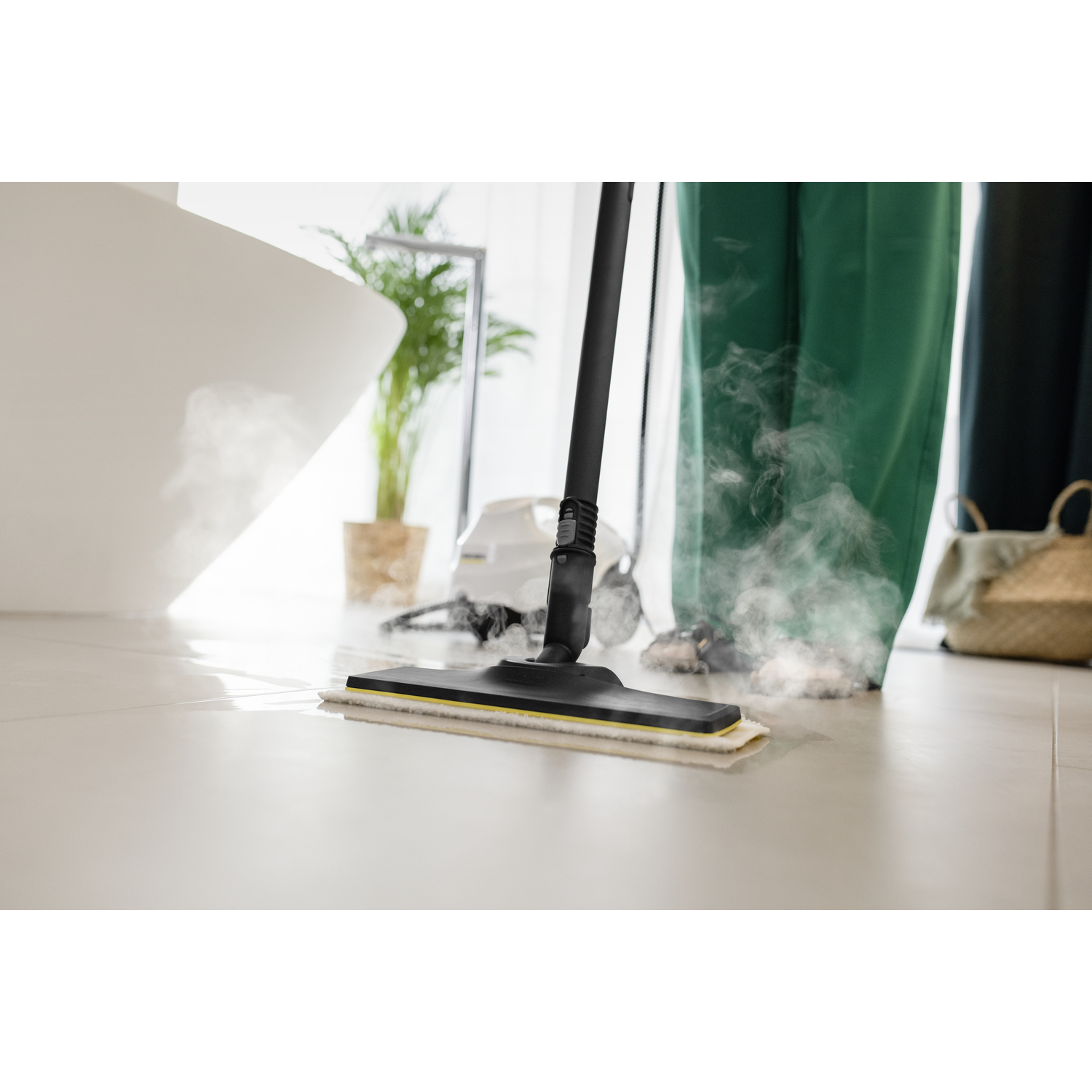 A person cleaning tiled floor with a steam mop. Steam coming out. White bathroom fixture.