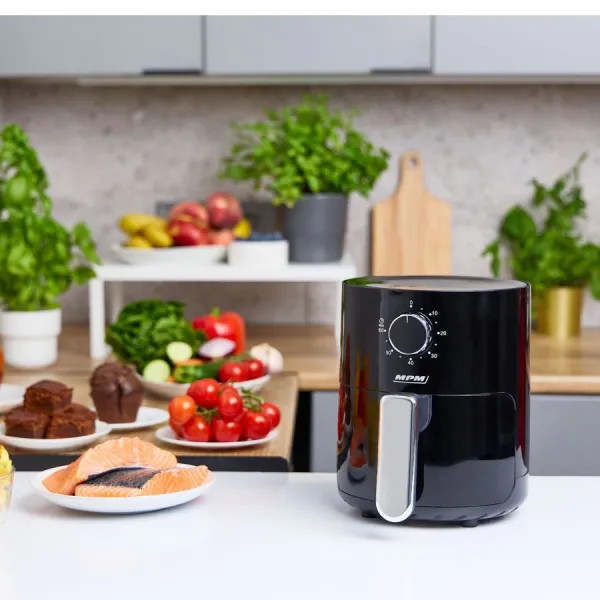 Czarna frytkownica z elementami sterującymi. Jedzenie i składniki są wokół niej ułożone.