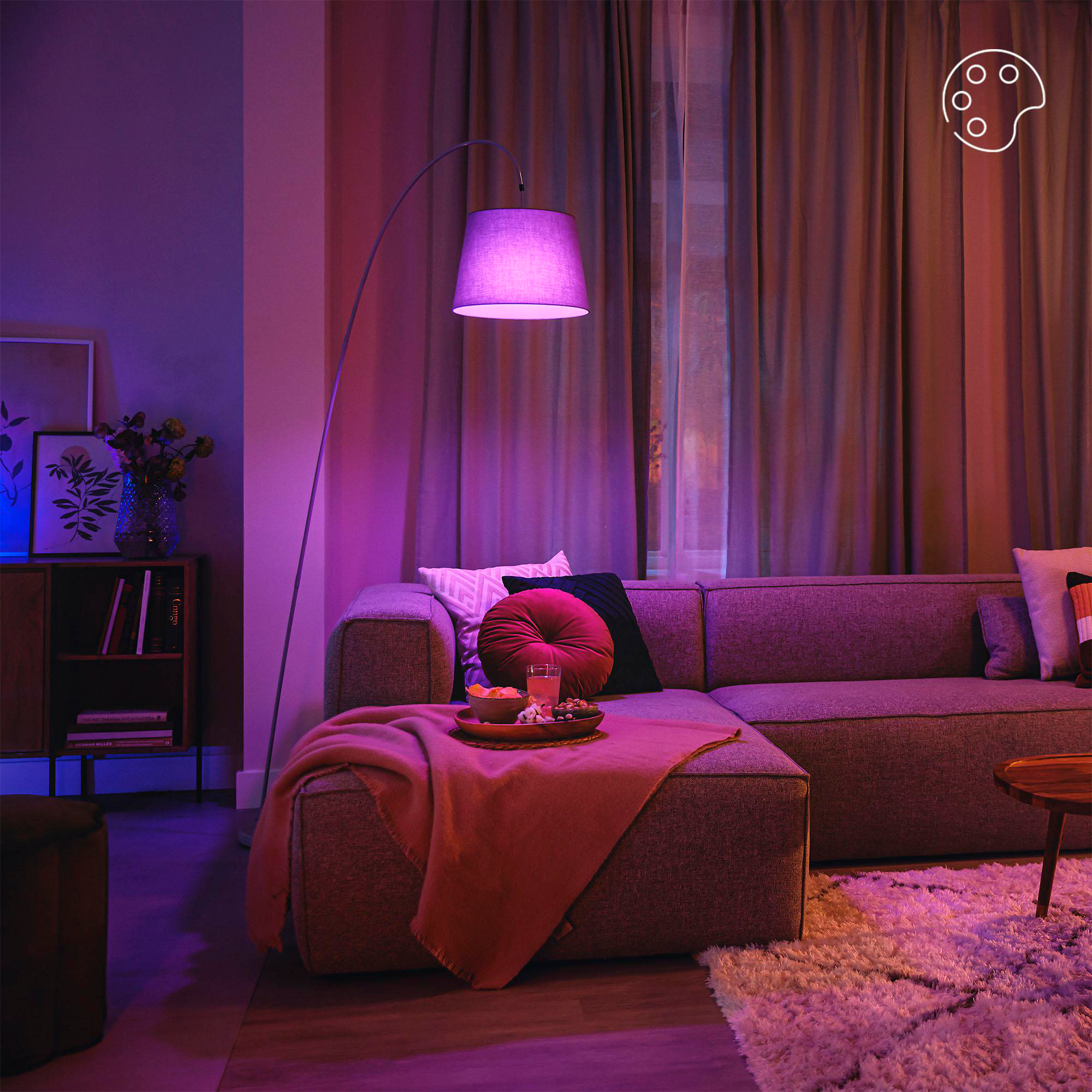 Ein Wohnzimmer mit einer lila Bogenlampe, einer Couch, einem Teppich und einem Tisch mit einem Tablett.