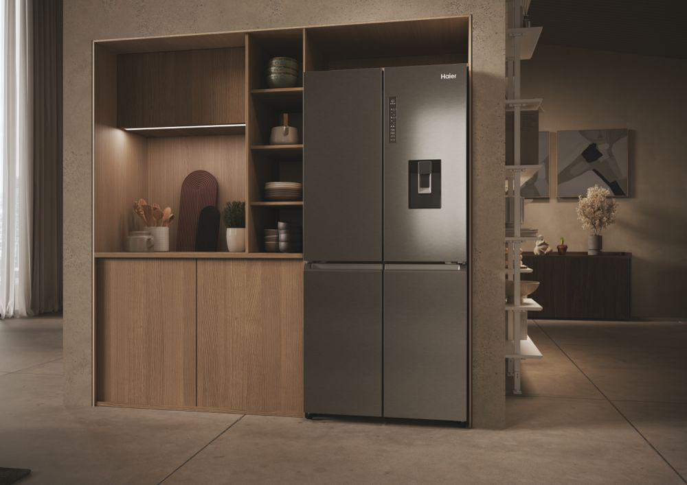 Ein Kühlschrank aus Edelstahl in einem Holzschrank. Der Kühlschrank hat einen Wasserspender.