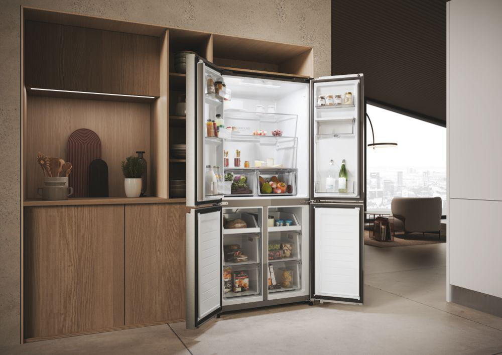 Ein moderner Kühlschrank mit offenen Türen, der Regale voller Lebensmittel in einer Küchenumgebung zeigt.