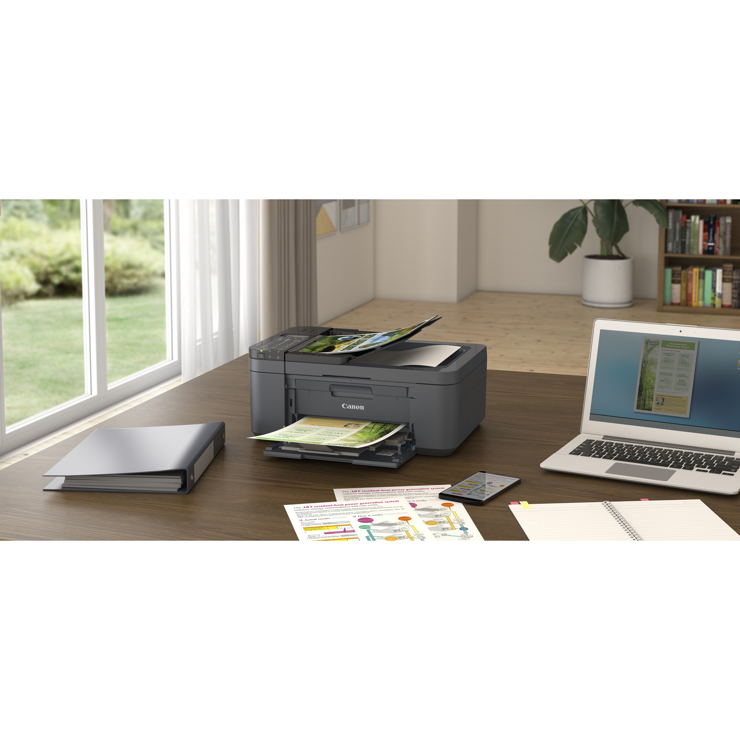 Printer on desk with papers, laptop, and a window in the background.