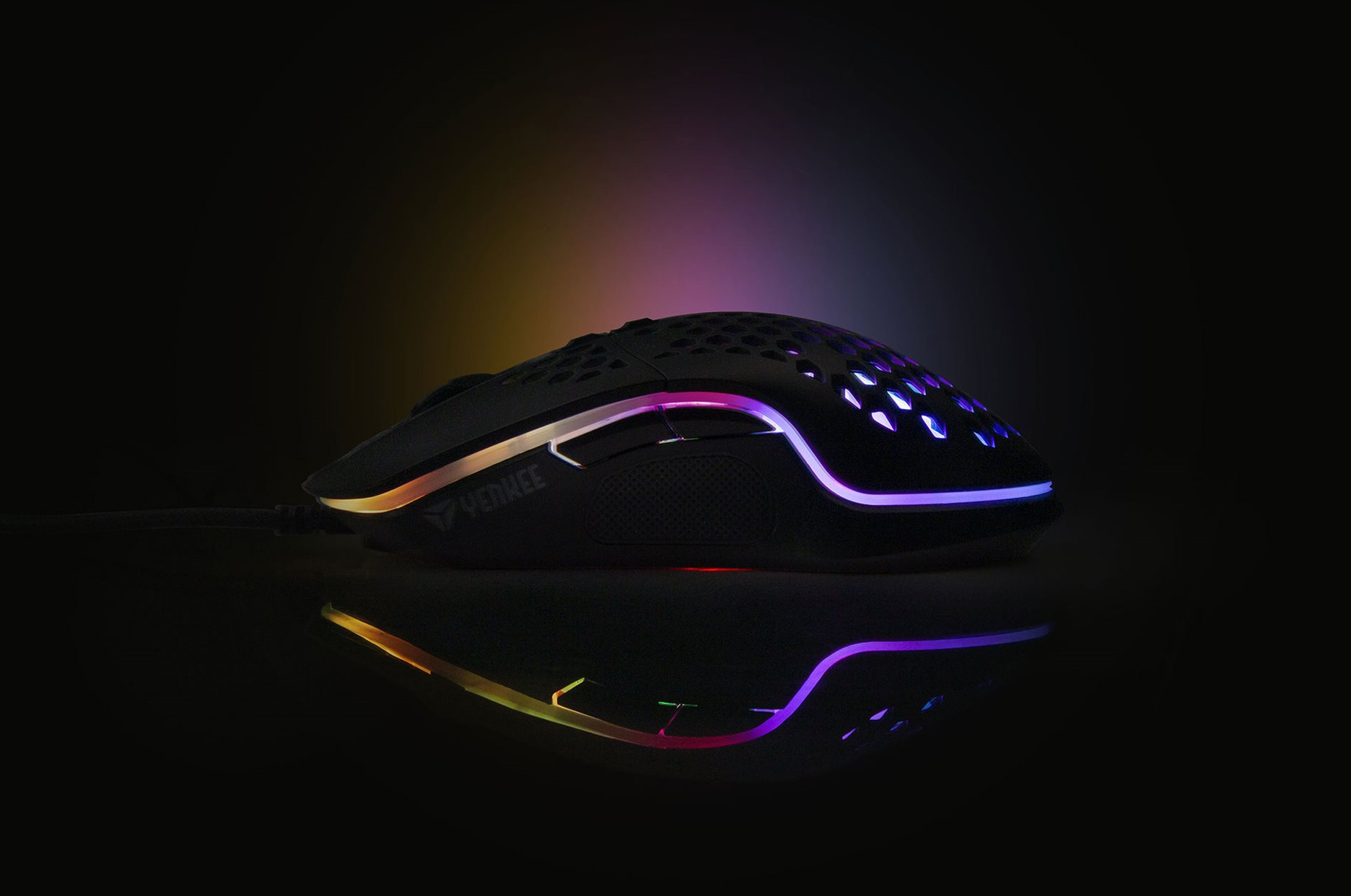 Fekete gamer egér. Az egéren RGB világítás van, és tükröződik a felületen.